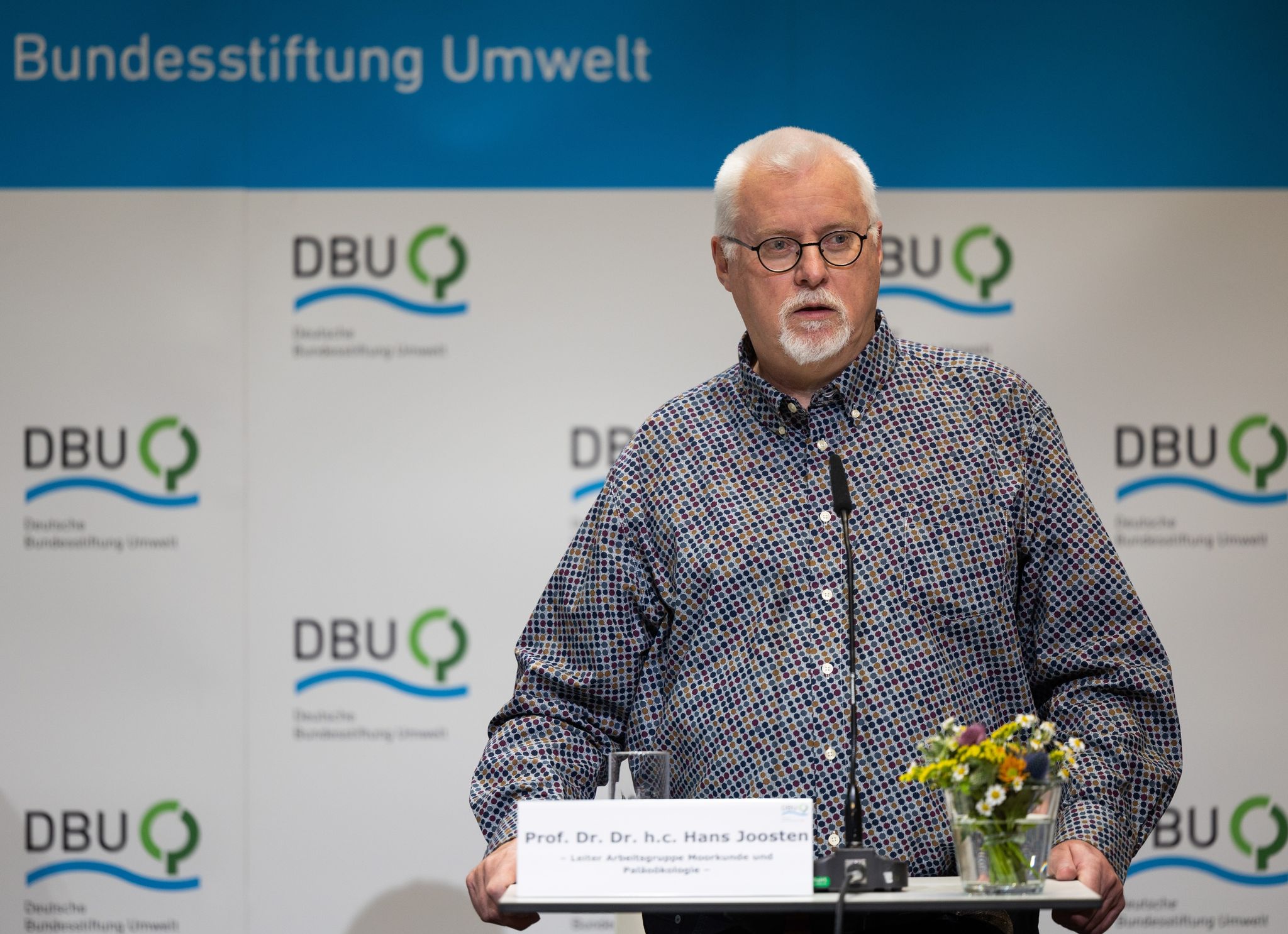 Der Greifswalder Forscher Hans Joosten spricht auf einer Bühne.