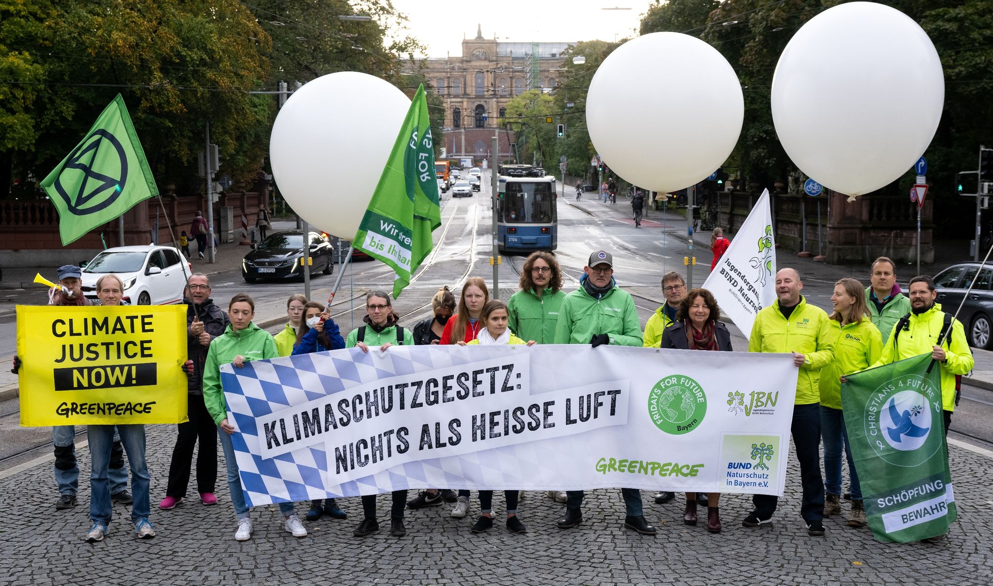 Mitglieder von BUND, Greenpeace und Fridays for Future demonstrieren in der Nähe des Landtages für besseren Klimaschutz.