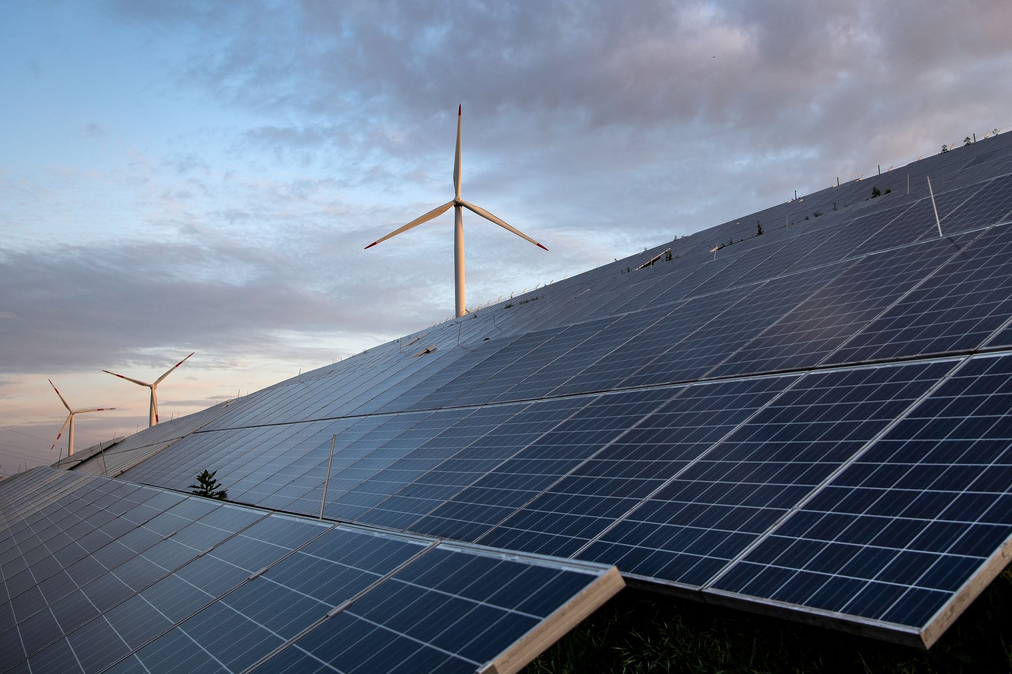 Windkraftanlagen stehen hinter Photovoltaikanlagen.