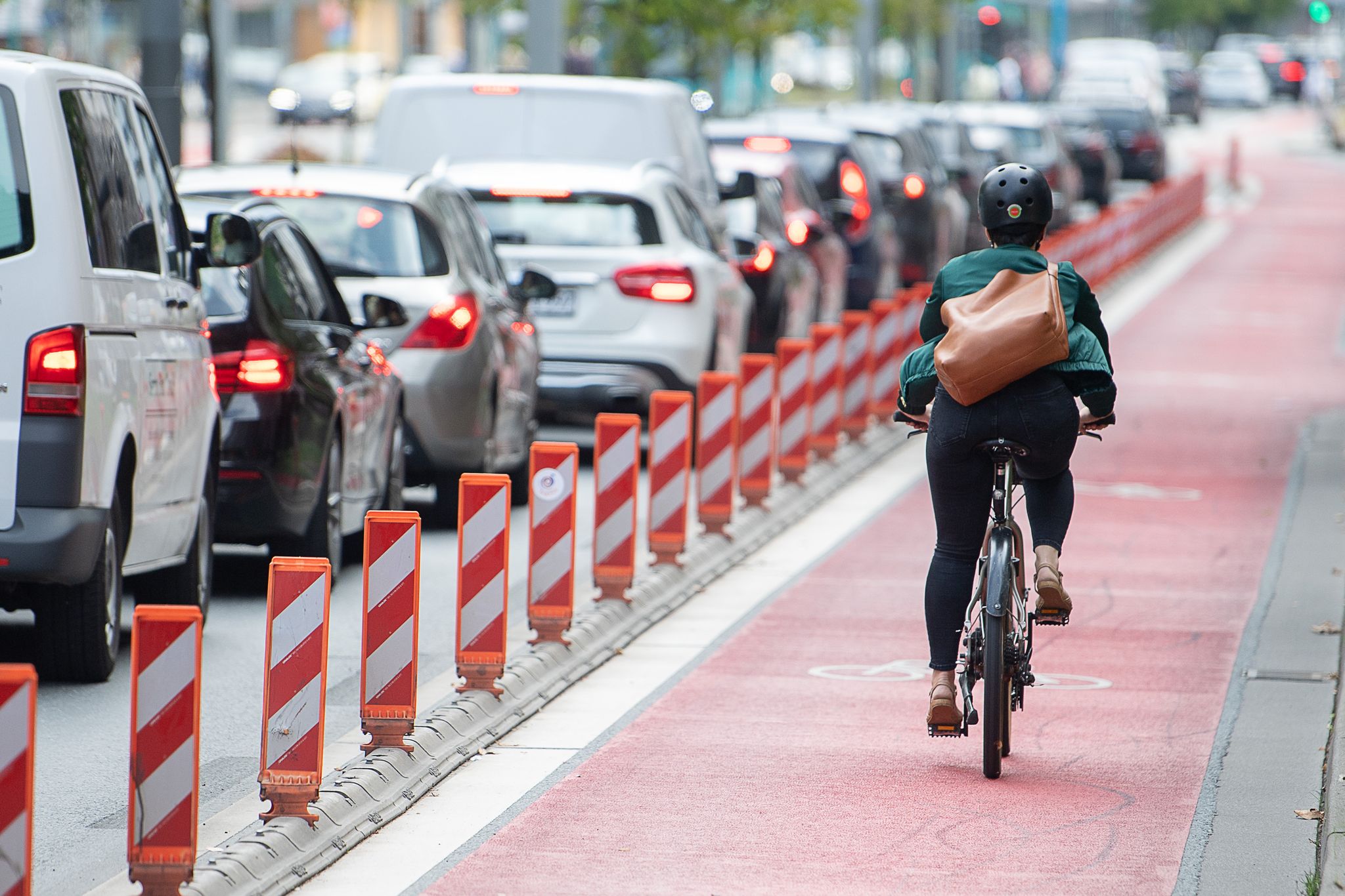 Eine Fahrradfahrerin fährt auf einer Fahrradspur an einer Straße. Die Sorge vor den Folgen der Klimakrise ist für die Menschen in Deutschland die stärkste Motivation, ihr eigenes Mobilitätsverhalten zu ändern.
