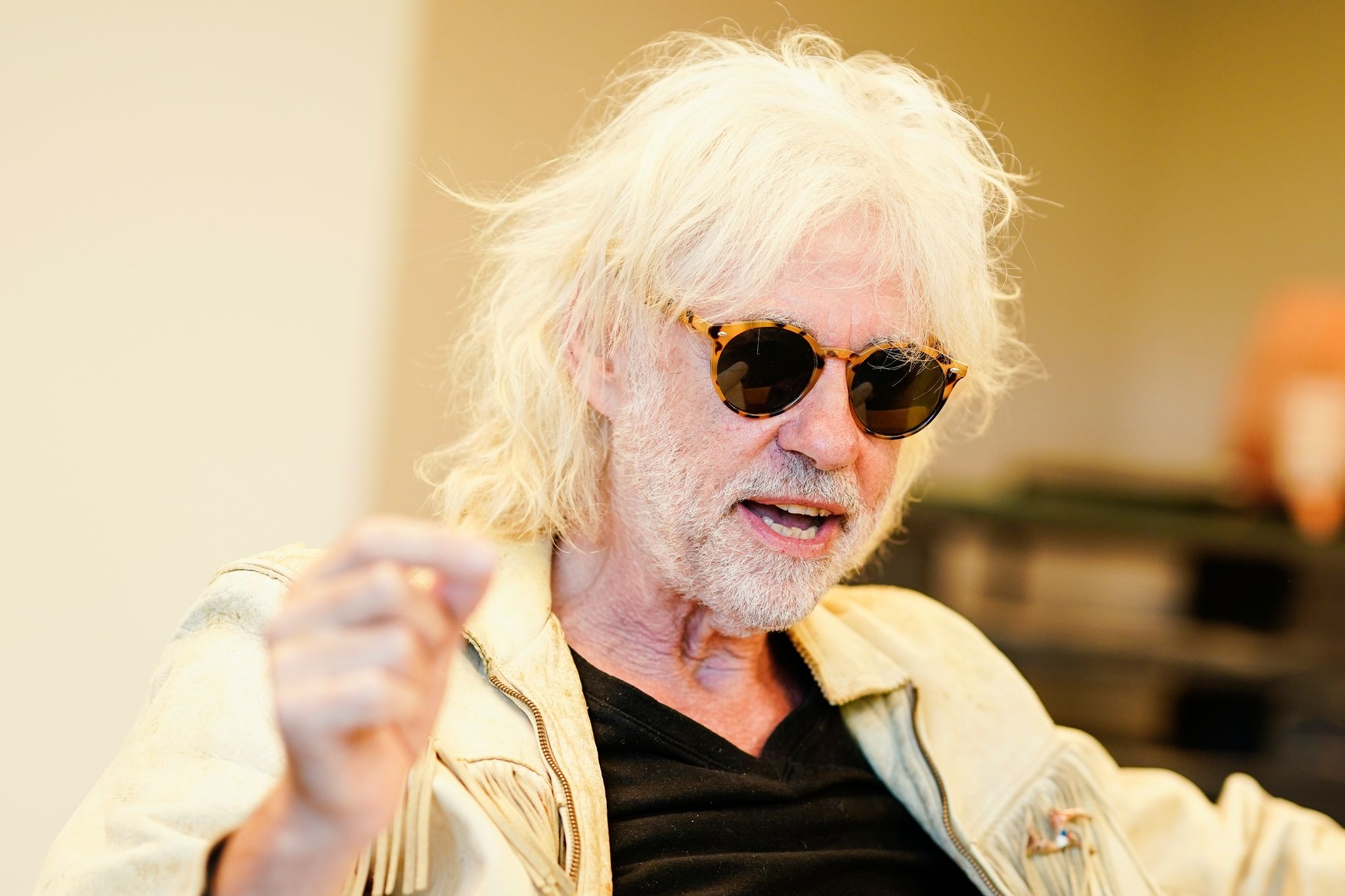 Der irische Rocksänger Bob Geldof, Mitbegründer der Gruppe The Boomtown Rats, gestikuliert während eines Gesprächs in einem Hotelzimmer.