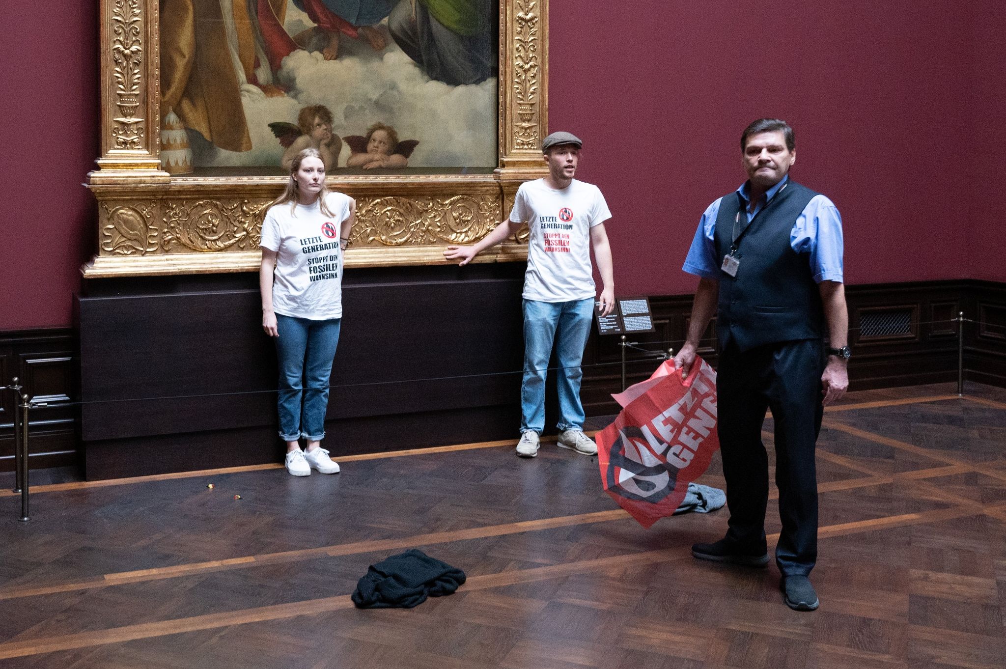 Zwei Umweltaktivisten der Gruppe «Letzte Generation» stehen in der Gemäldegalerie Alte Meister an dem Gemälde «Sixtinische Madonna» von Raffael.