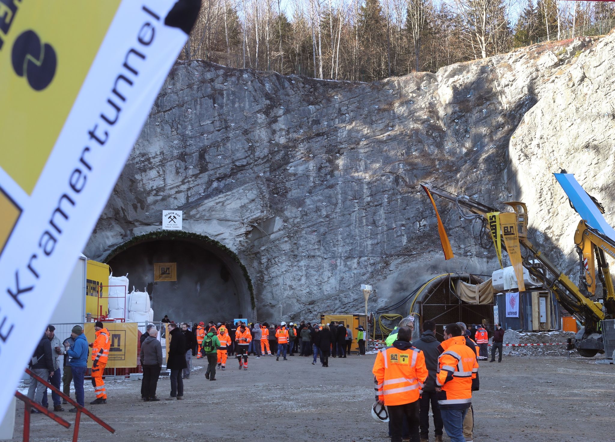 Arbeiter und Gäste stehen nach dem offiziellen Tunnelanschlag vor dem Nordportal des Kramertunnels.