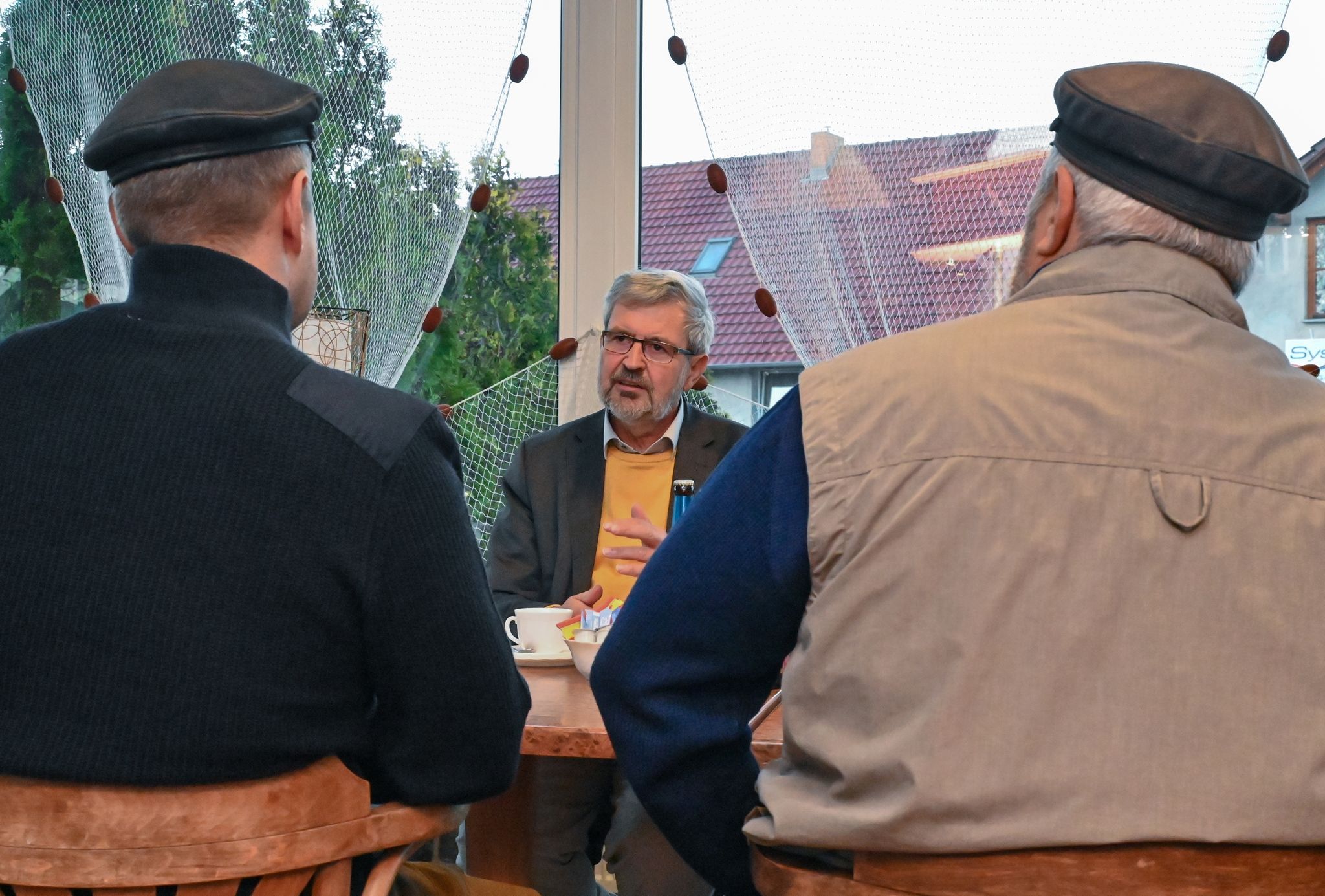 Axel Vogel (M), Umweltminister von Brandenburg, spricht mit zwei Oder-Fischern.