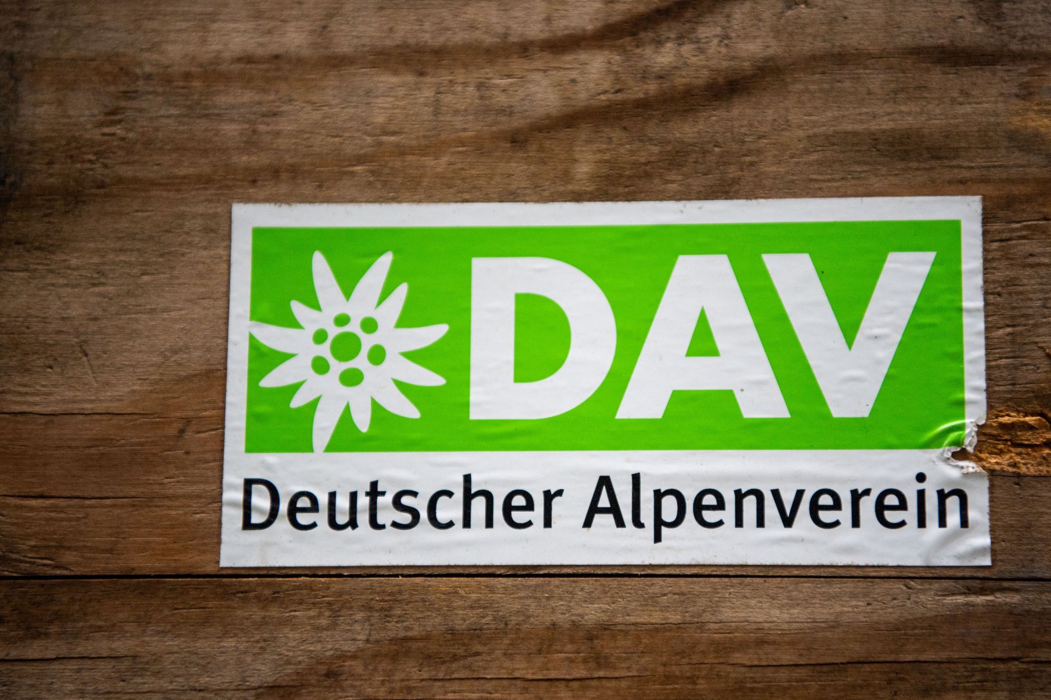Das Logo des Deutschen Alpenverein (DAV) klebt auf einer Holzbox.