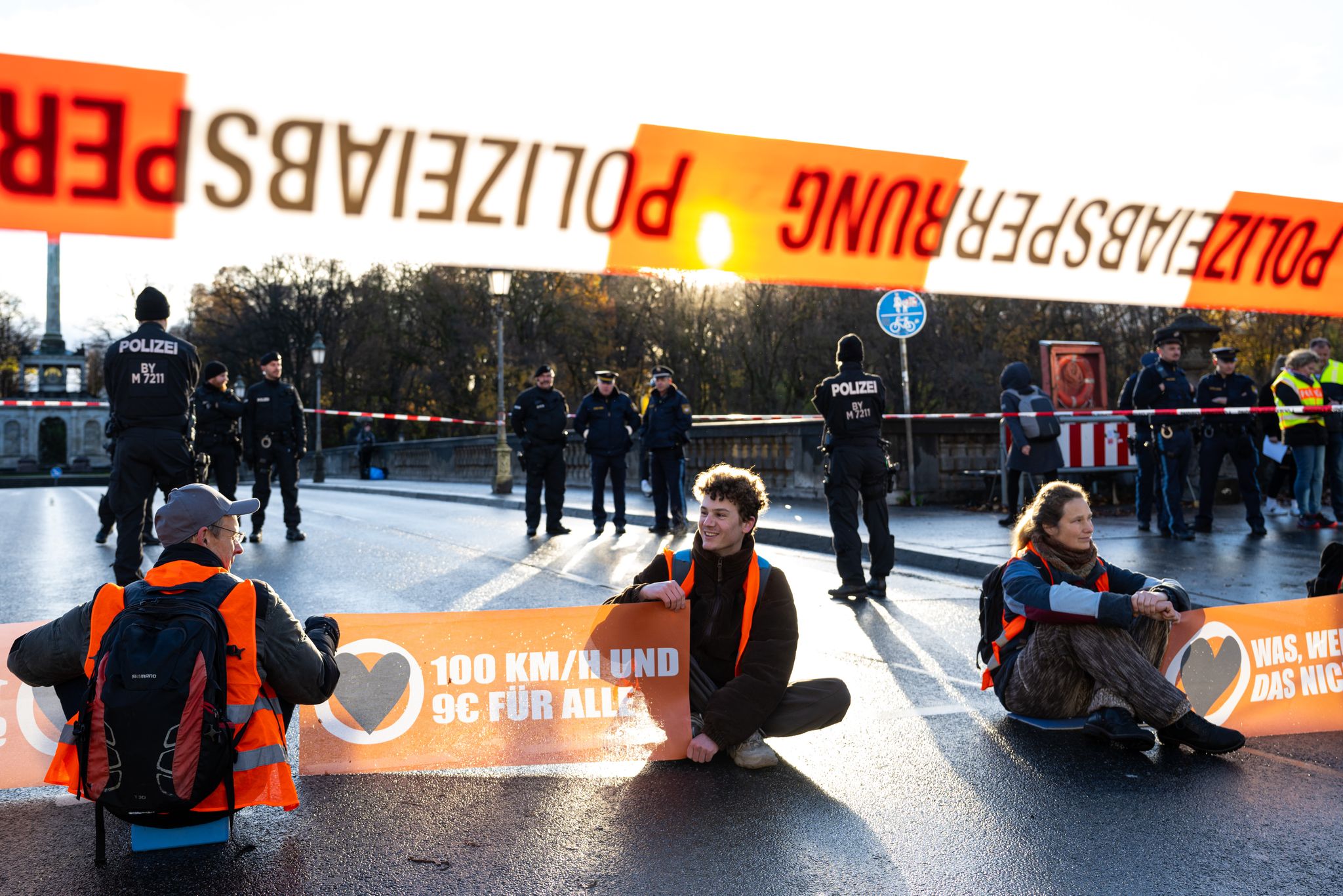 Aktivisten der Umweltschutzbewegung «Letzte Generation» blockieren auf einer Straße in München den Verkehr.