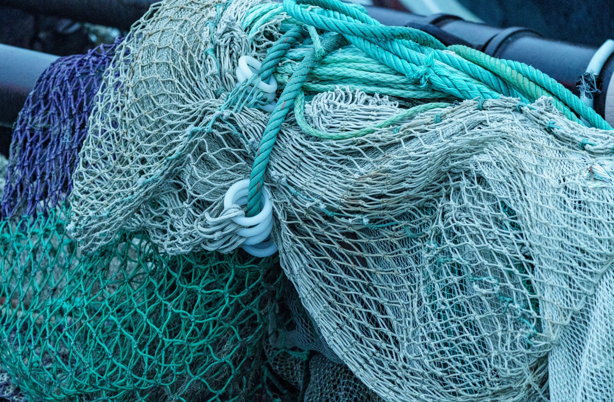 Netze lagern auf der Pier eines Fischereihafens.