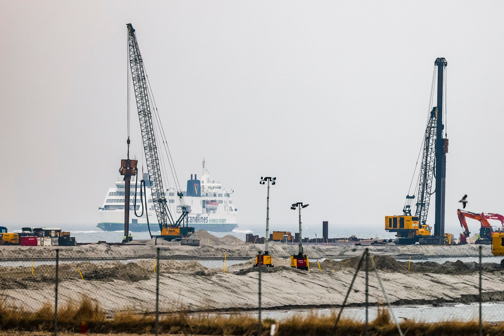 Eine Fähre der Reederei Scandlines läuft neben der Baustelle des Ostseetunnels in Richtung Dänemark aus.