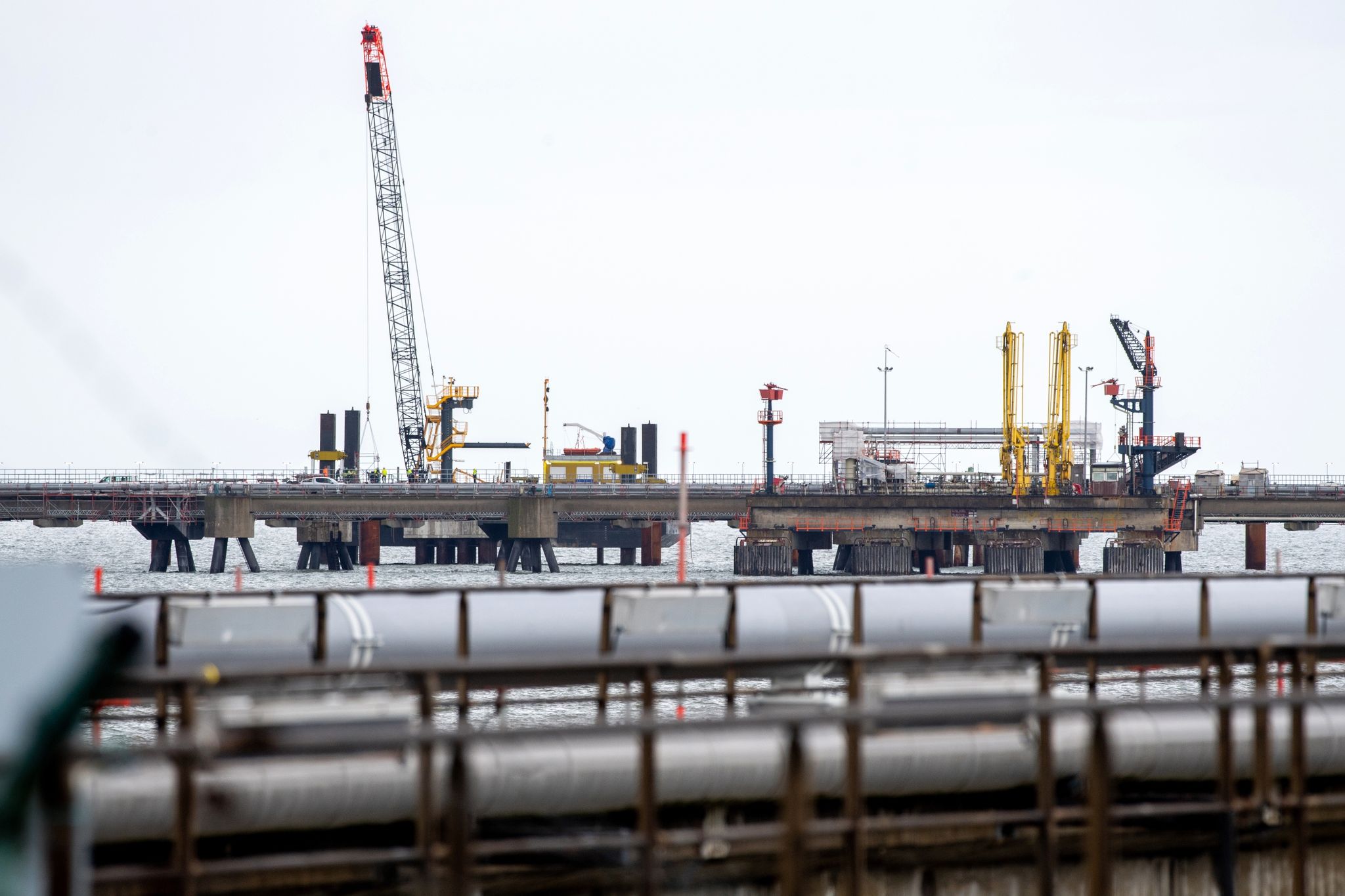Technische Anlagen und ein Kran stehen auf dem Anleger für das LNG-Terminal in der Nordsee vor Wilhelmshaven.
