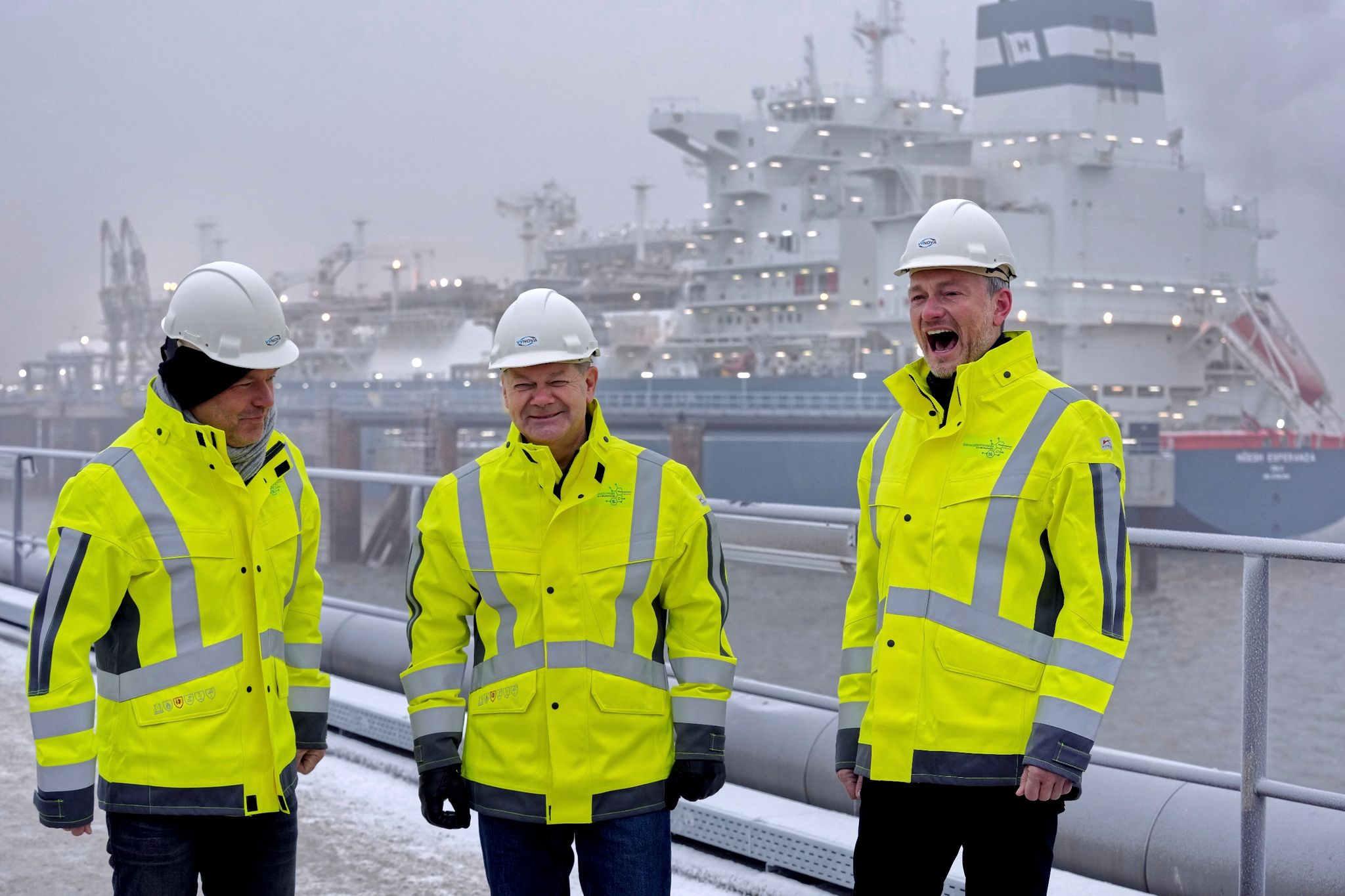 Robert Habeck (Bündnis 90/Die Grünen, l-r), Olaf Scholz (SPD) und Christian Lindner (FDP) stehen vor dem Spezialschiff «Höegh Esperanza».