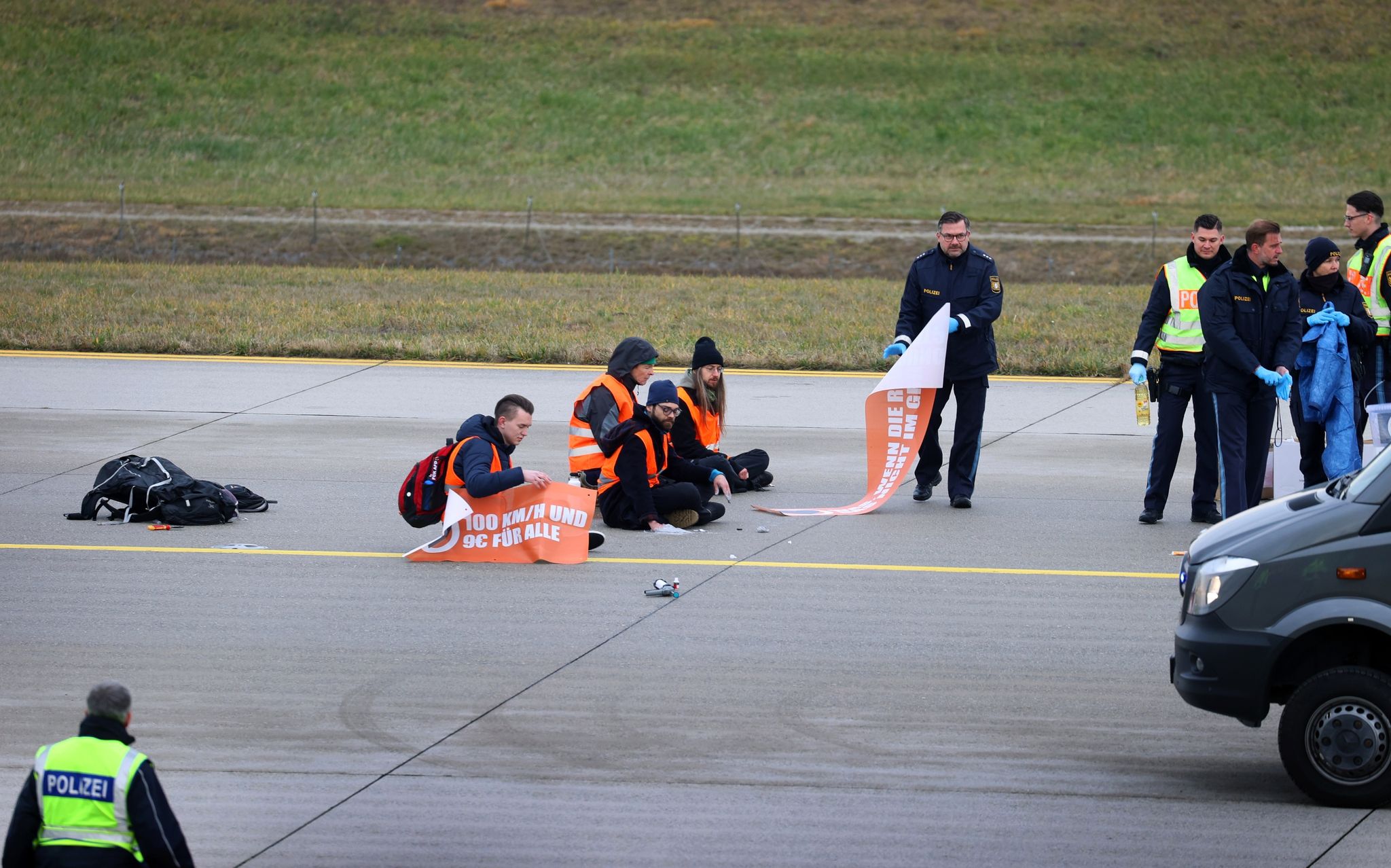 Klimaaktivisten sitzen auf dem Zubringer einer Start-und Landebahn am Airport Franz-Josef-Strauß.