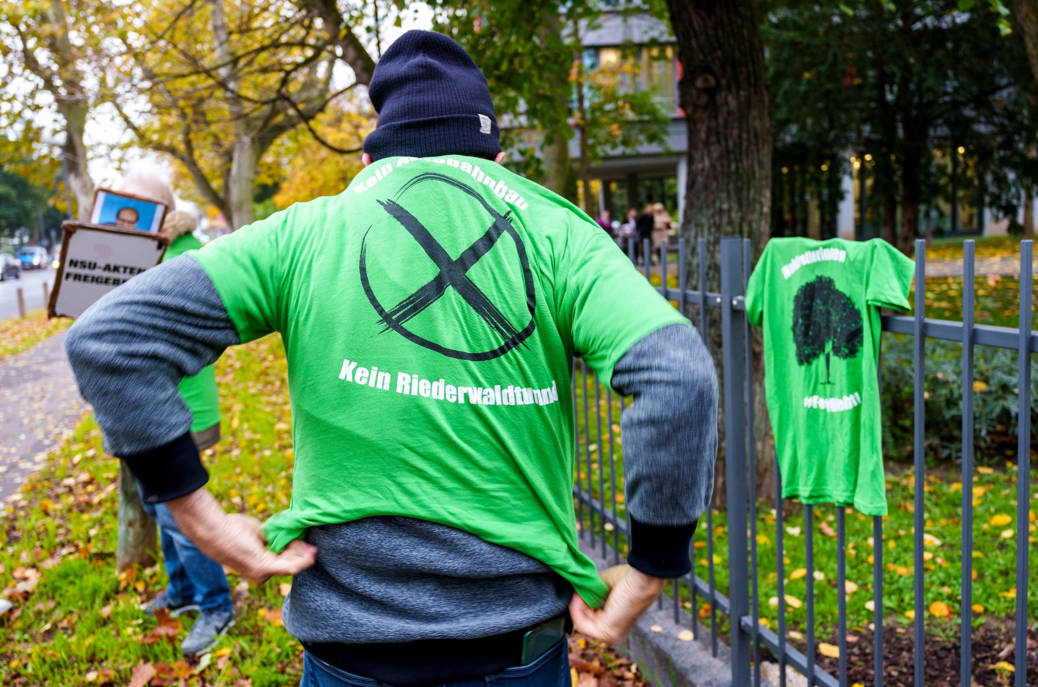 Ein Demoteilnehmer hat ein T-Shirt „Kein Autobahnbau Kein Riederwaldtunnel“ an.