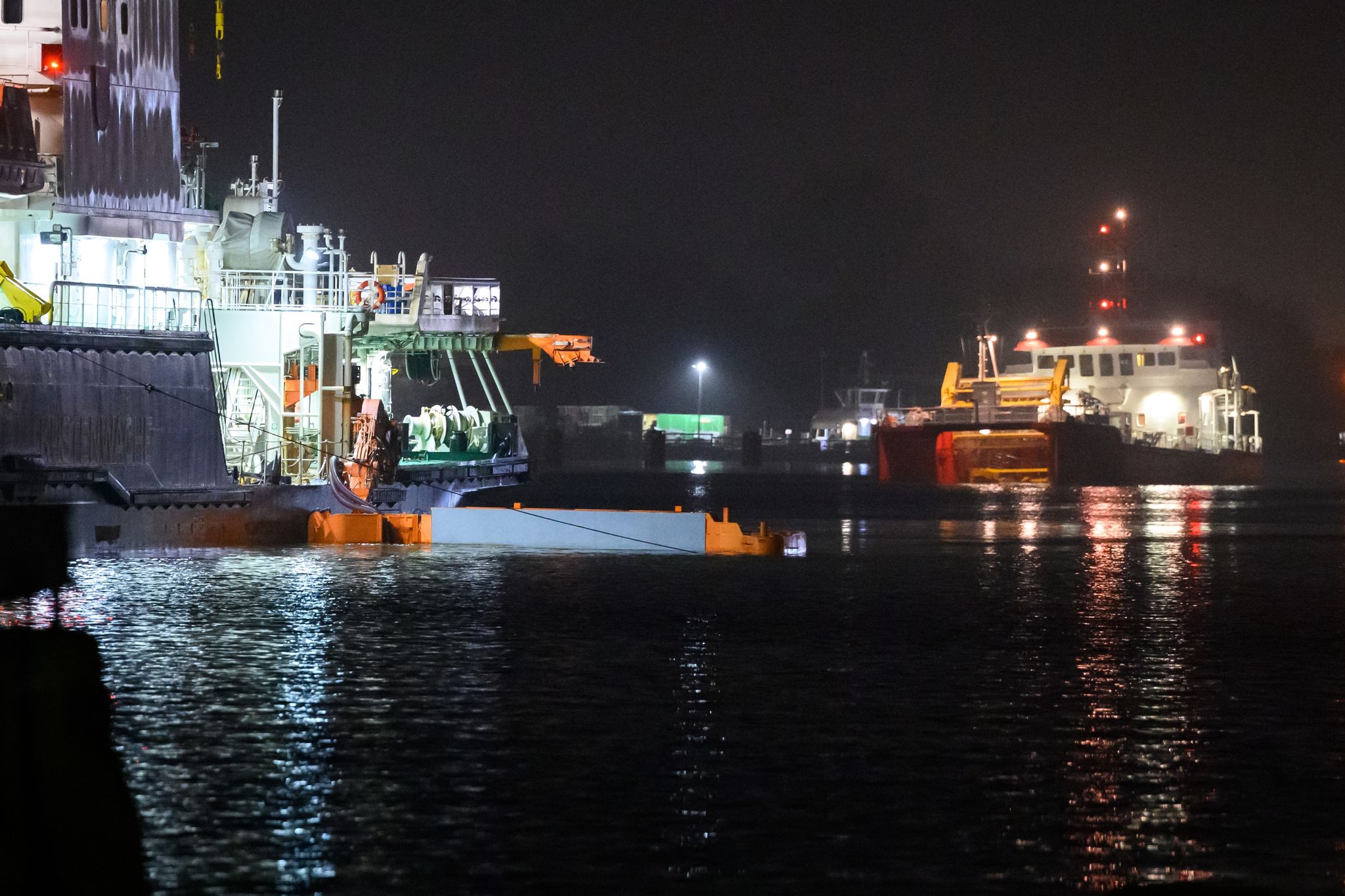 Ein Mehrzweckschiff (l) fährt mit dem Reinigungsapparat im Nord-Ostsee-Kanal um das Öl aufzunehmen.