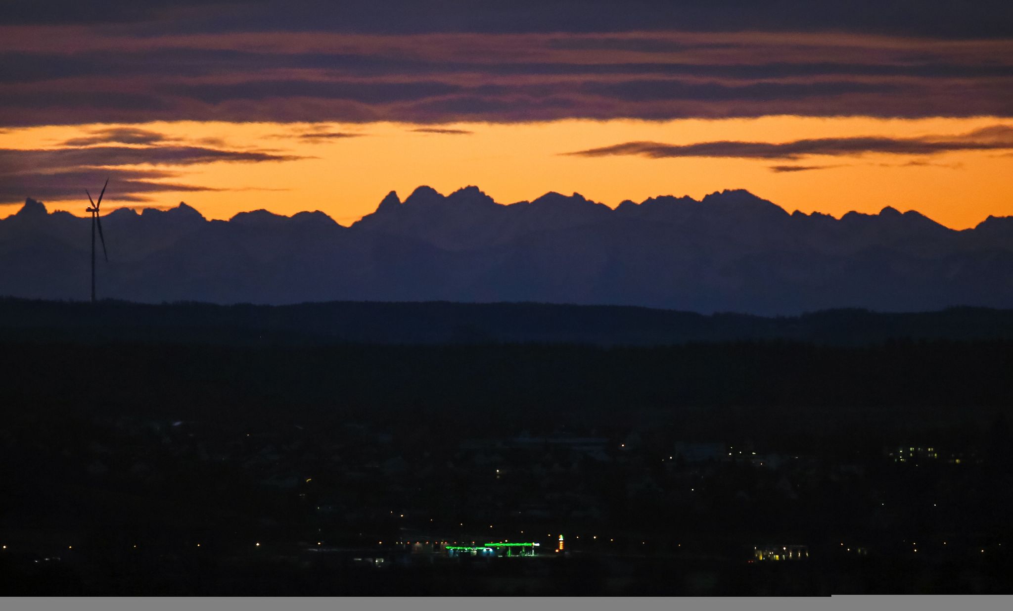 Während Oberschwaben noch im Dunkeln liegt, zeigen sich kurz vor Sonnenaufgang die Alpen.