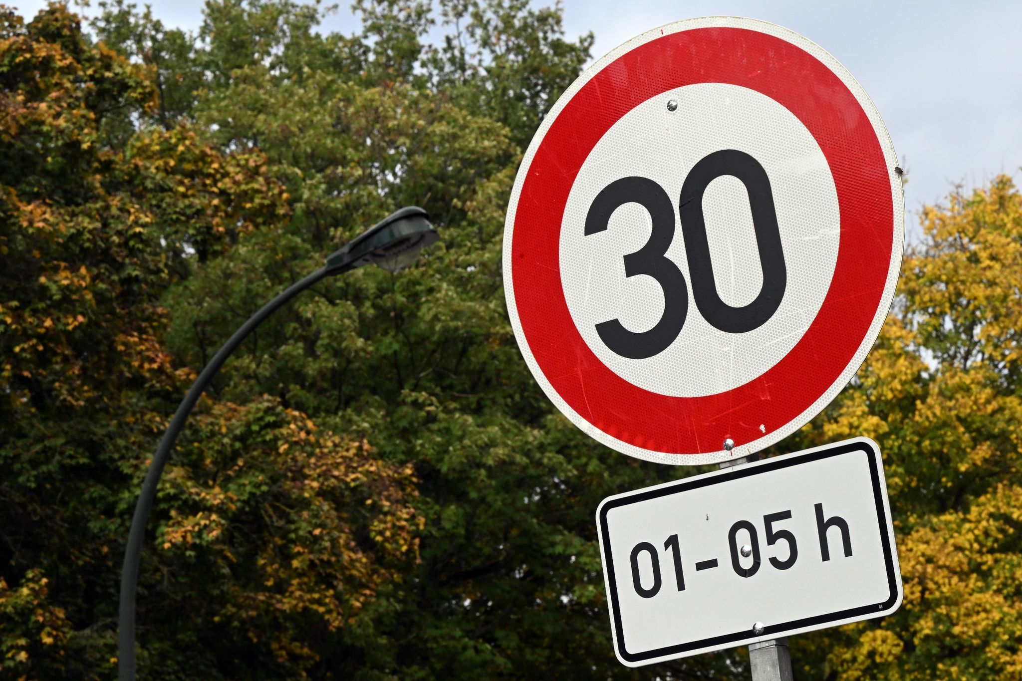 Ein Tempo 30-Schild steht an einer Straße.
