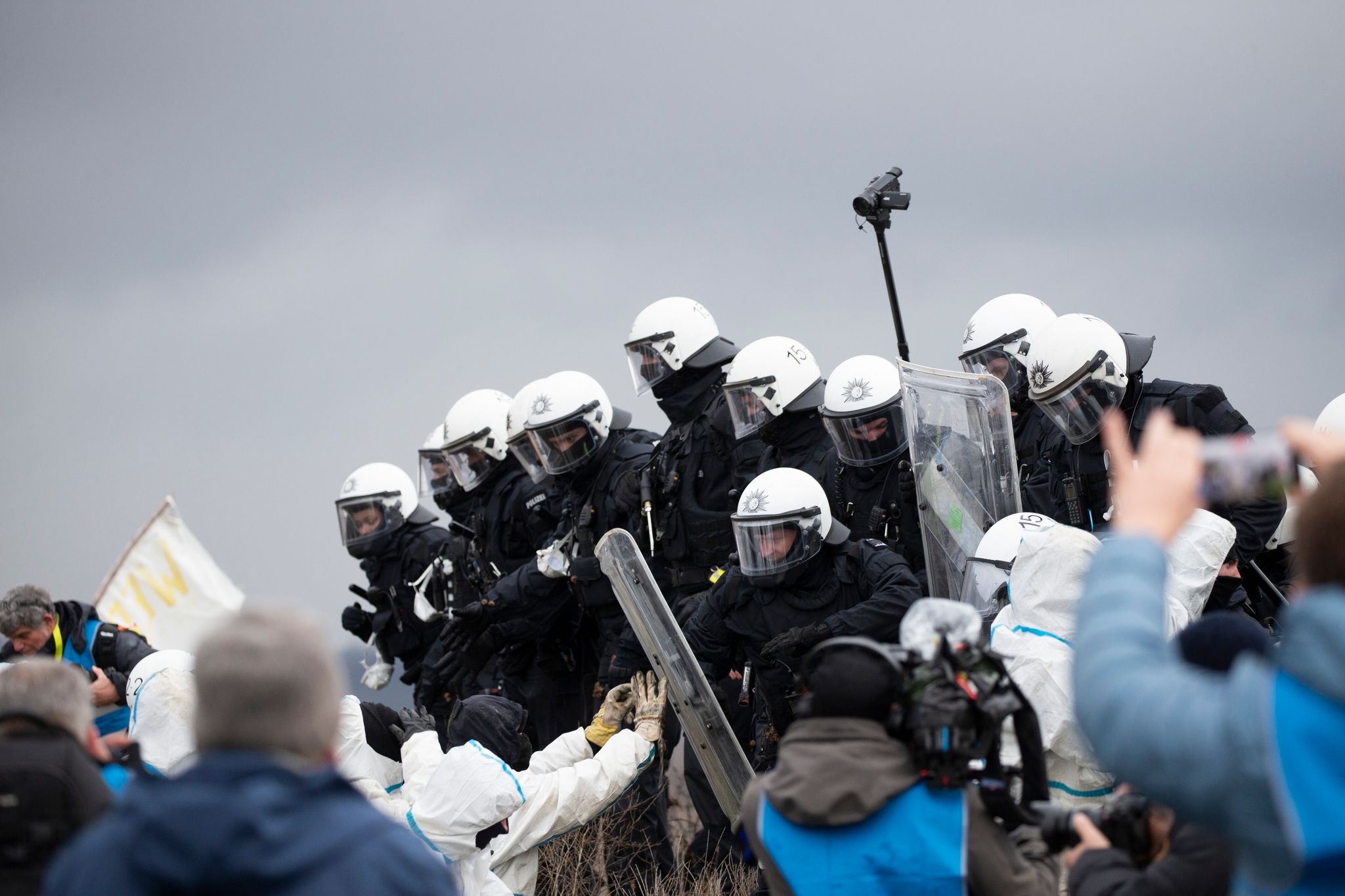 Polizeibeamte drängen Aktivisten von einem Erdwall in Lützerath zurück. Das von Aktivisten besetzte Braunkohledorf soll laut Planungen der Polizei wohl Anfang des kommenden Jahres geräumt werden.