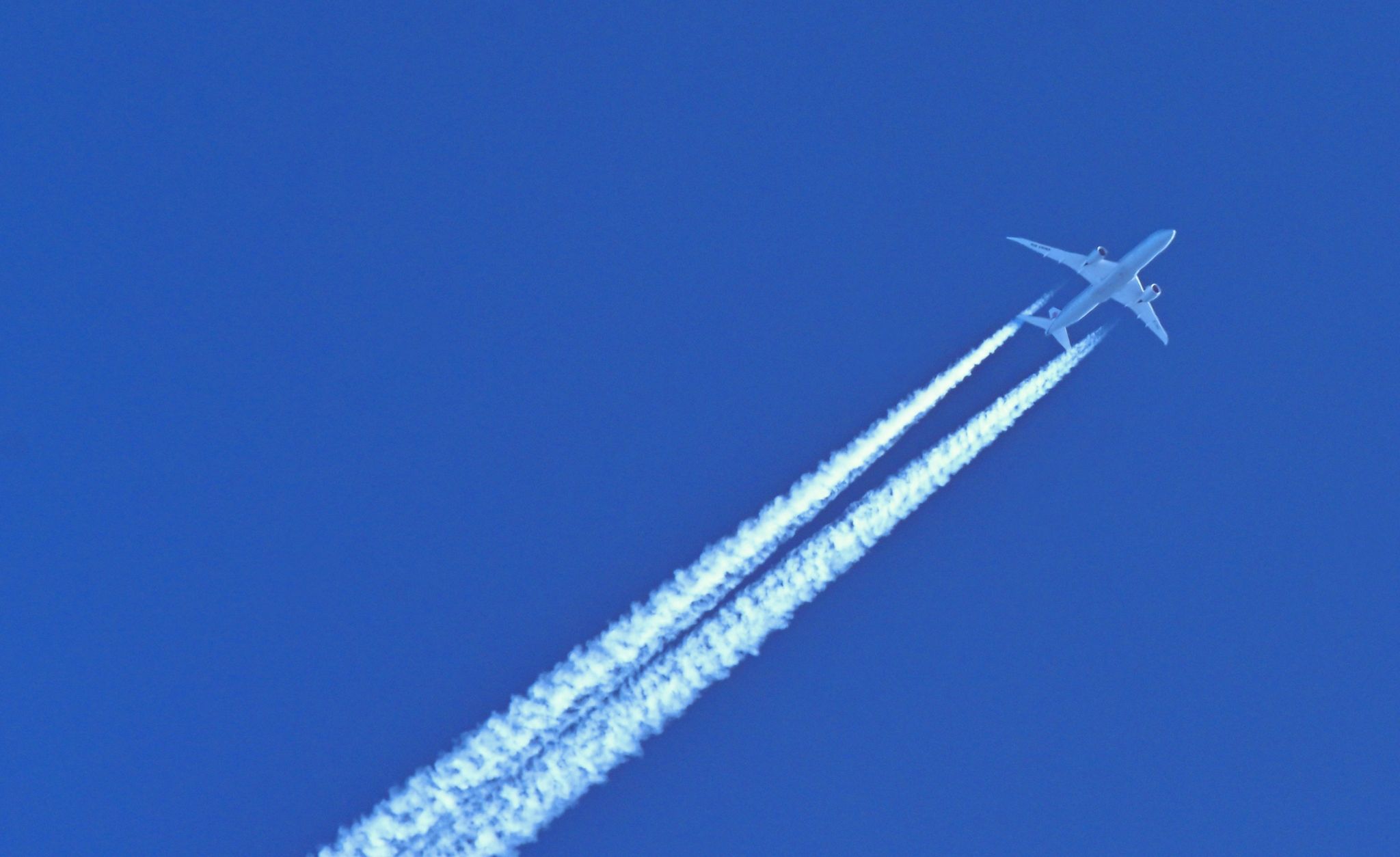 Schönes Motiv aber schlecht für Umwelt und Klima: Ein Flugzeug hinterlässt am blauen Himmel Kondensstreifen.
