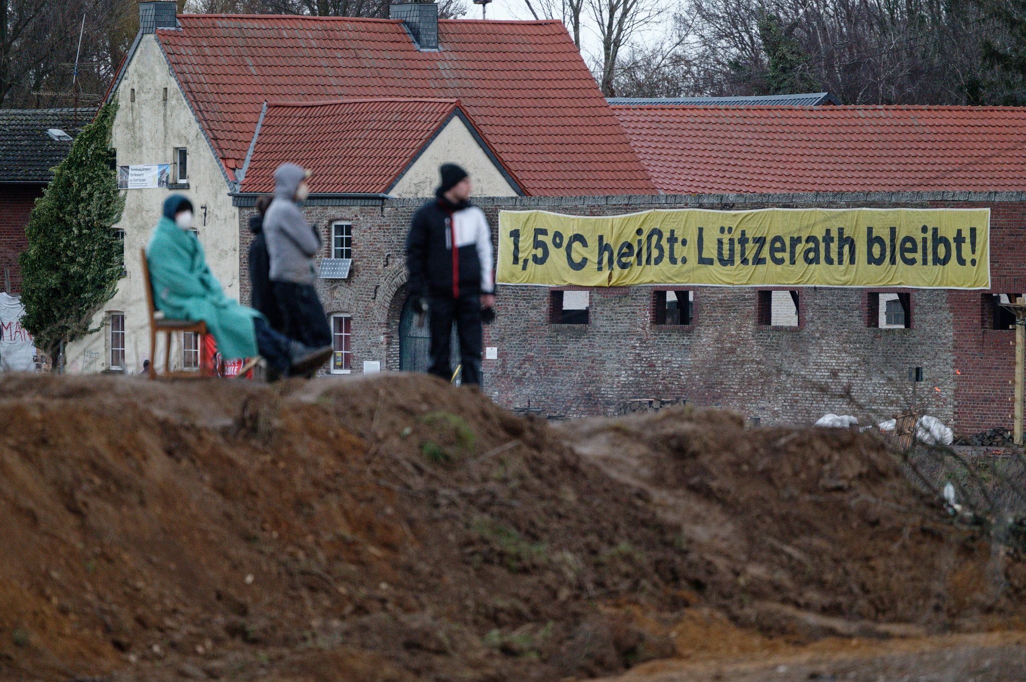 An einem Haus im Dorf Lützerath hängt ein Banner mit der Aufschrift « 1,5 Grad Celsius heißt: Lützerath bleib».