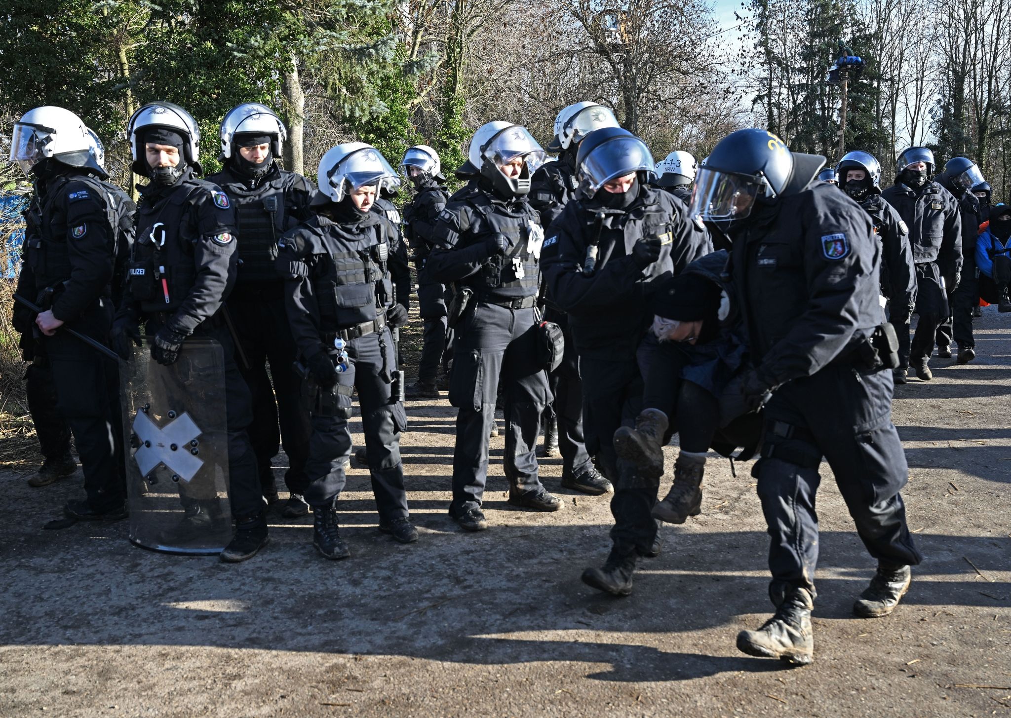 Polizisten tragen bei der Räumung von Lützerath einen Demonstranten fort.