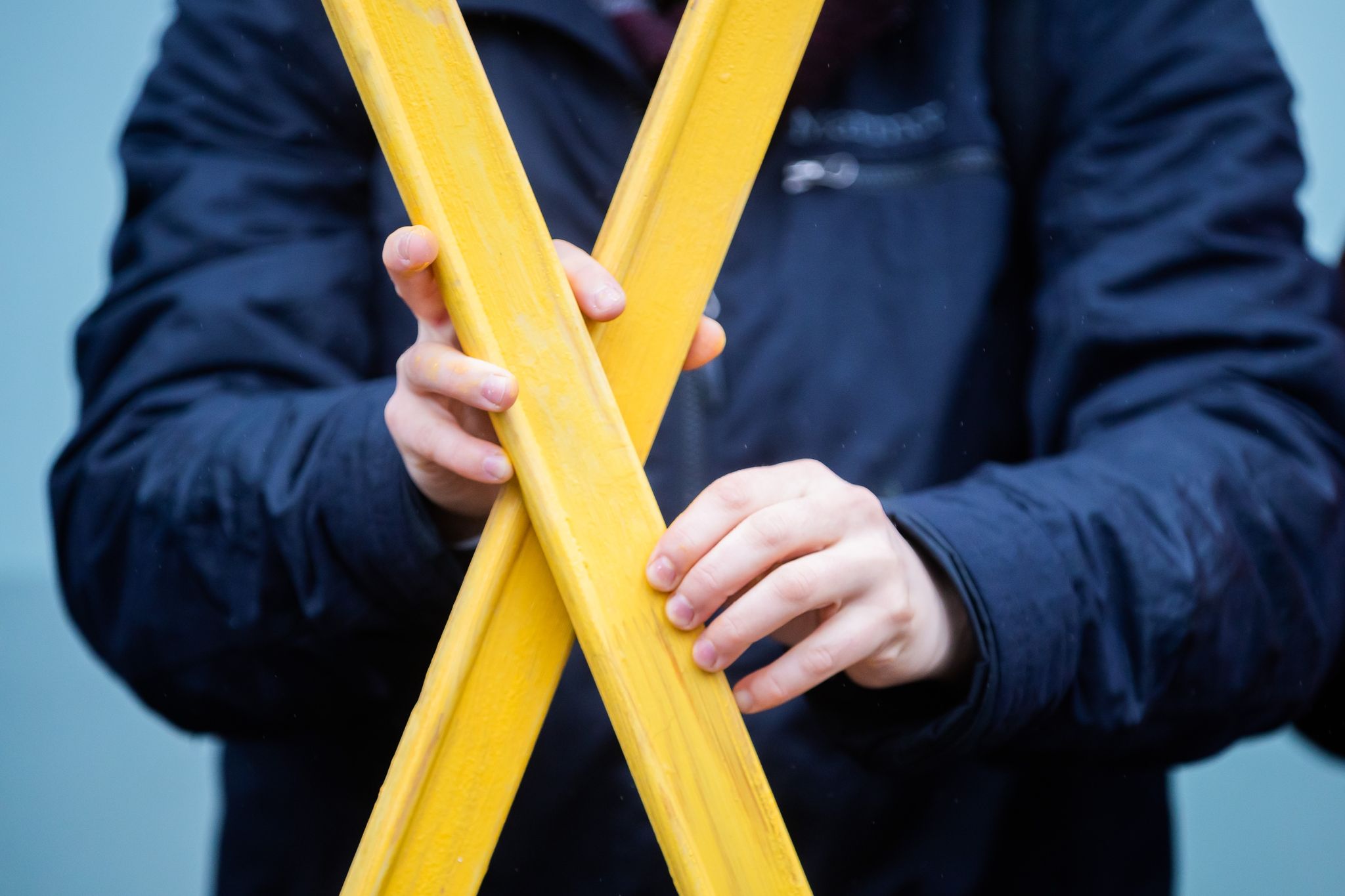 Eine Person hält ein gelbes Kreuz des Widerstands in den Händen.