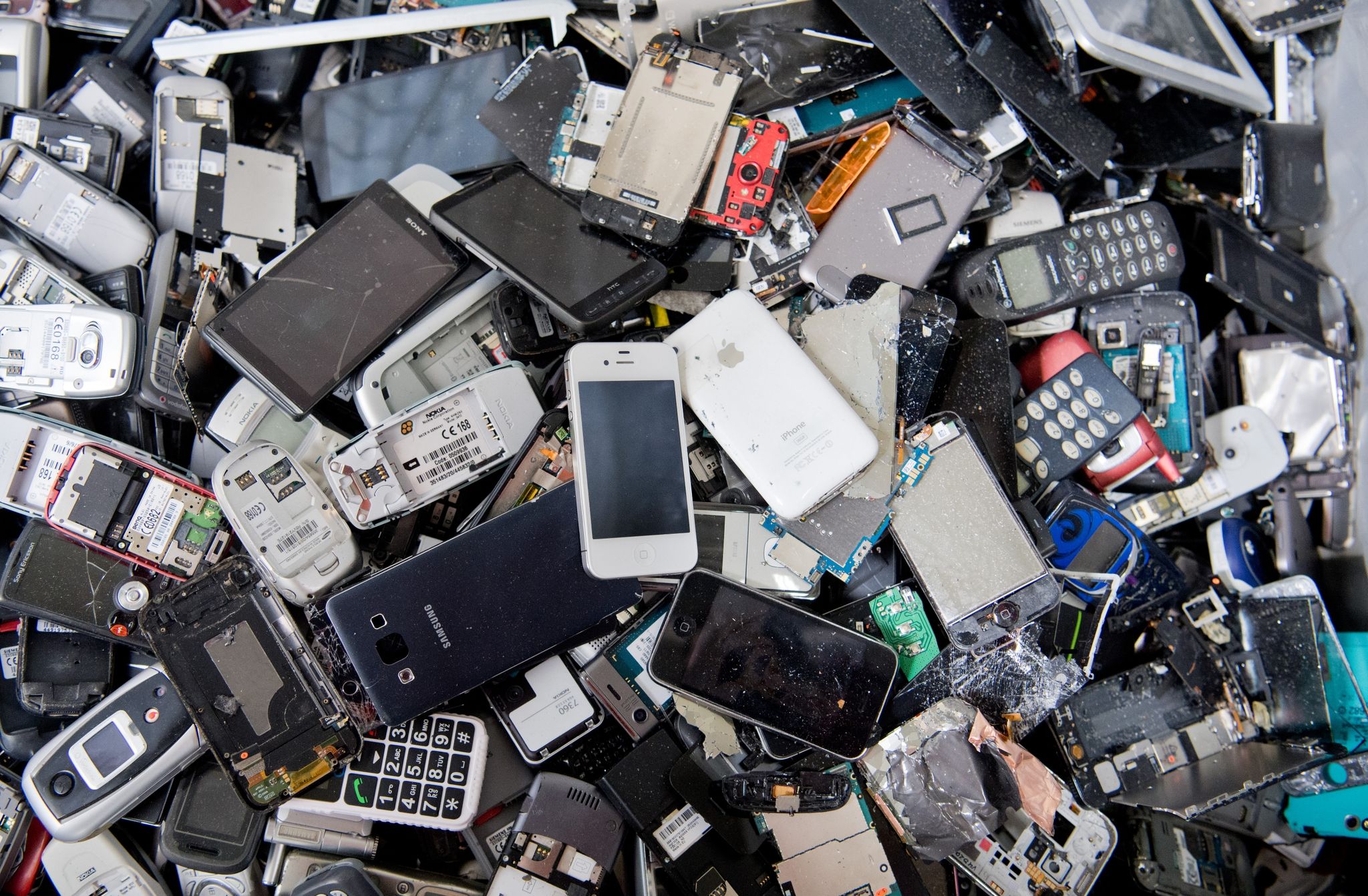 Alte Handys und Smartphones liegen in einem Container, ehe sie geschreddert werden.