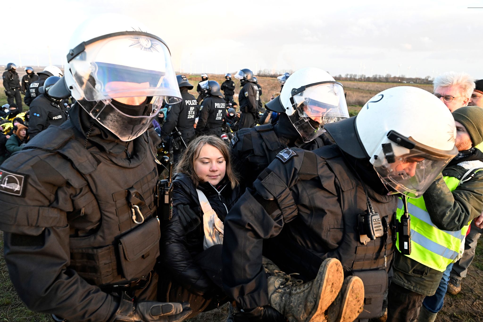Polizisten tragen die schwedische Klimaaktivistin Greta Thunberg (M) aus einer Gruppe von Demonstranten und Aktivisten heraus und vom Rand des Braunkohlentagebaus Garzweiler II weg.