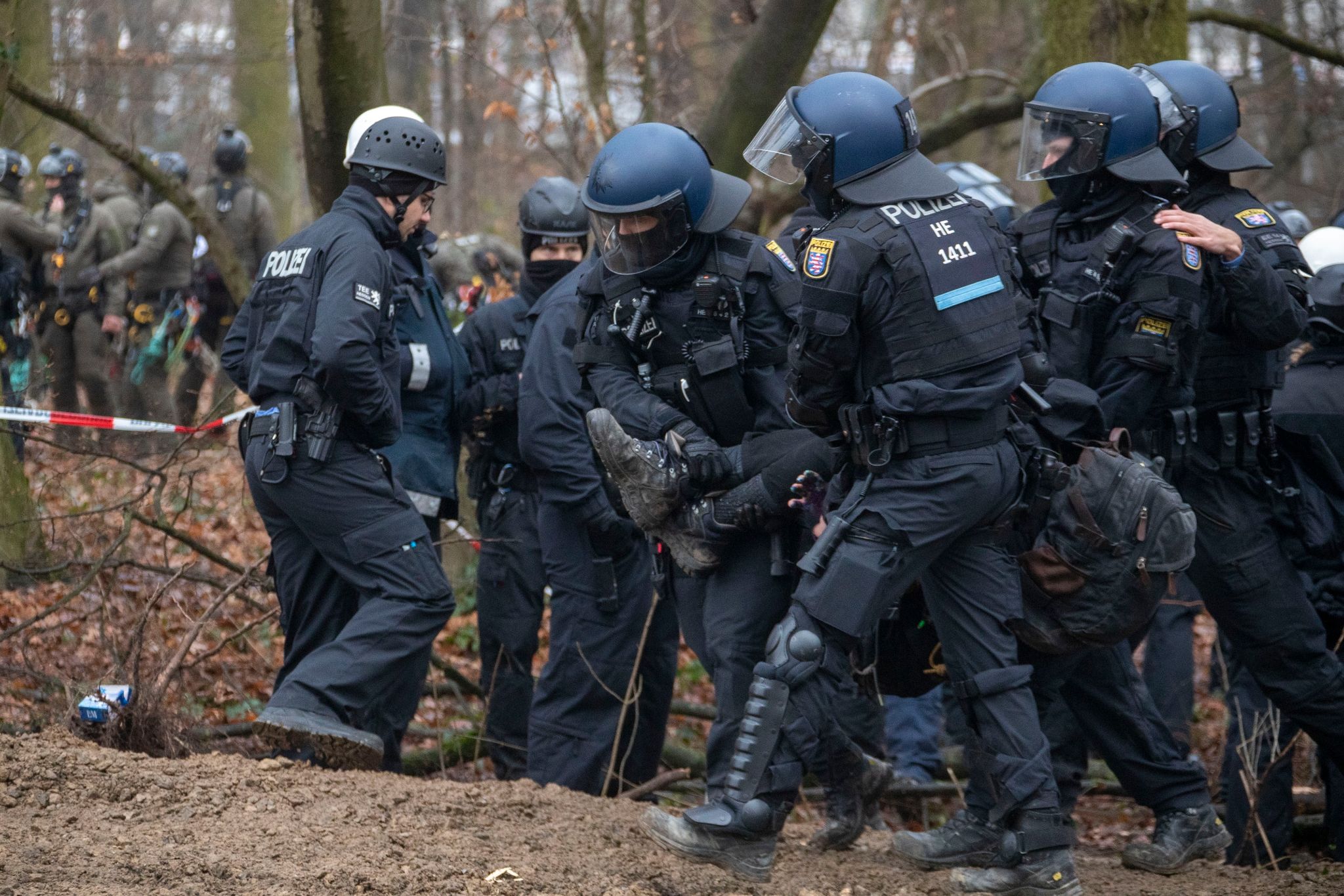 Polizisten tragen einen Aktivisten im Fechenheimer Wald vom Protestcamp.