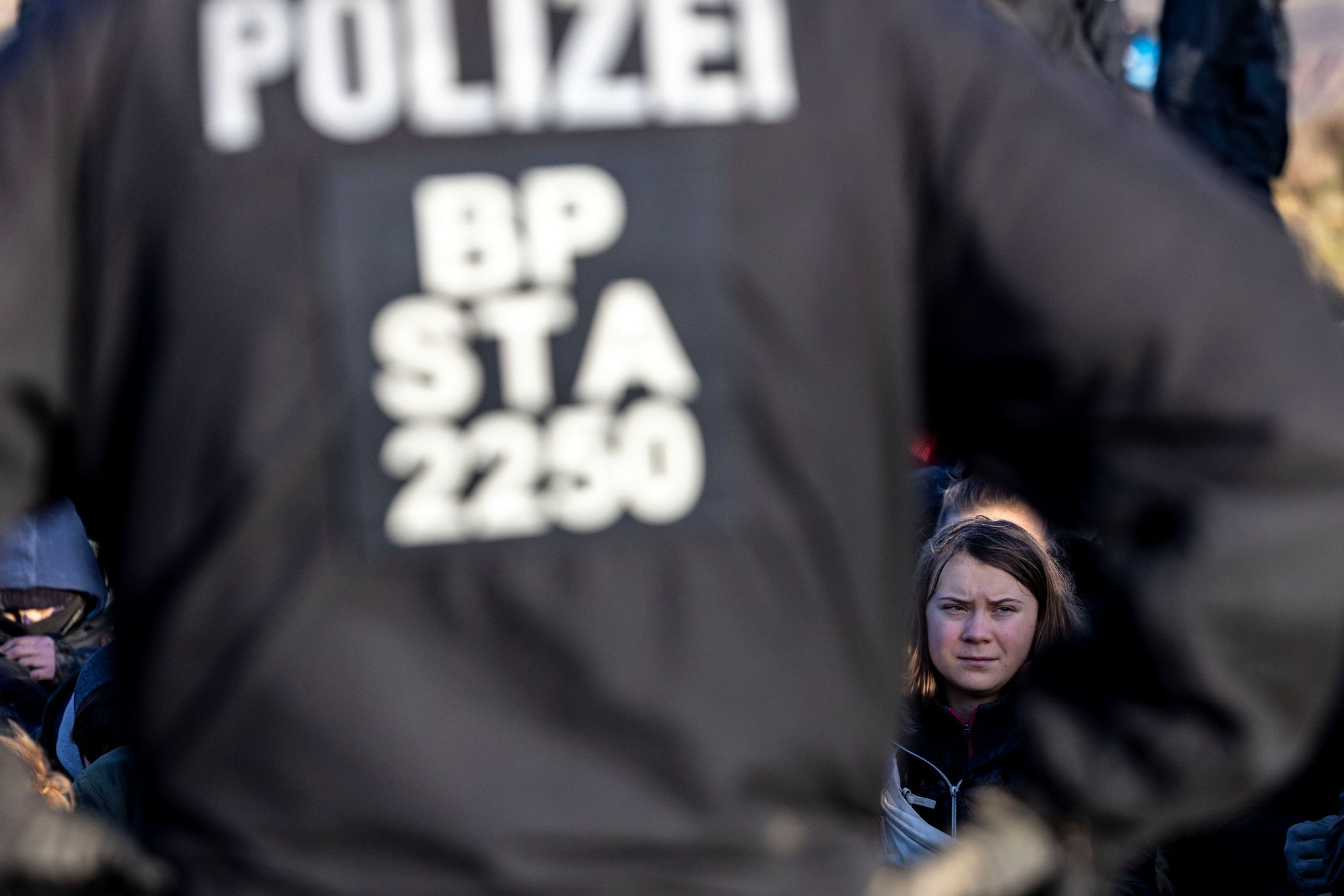 Polizisten stehen vor Demonstrantierenden, darunter auch die schwedische Klimaaktivistin Greta Thunberg, am Rand des Braunkohlentagebaus Garzweiler II.