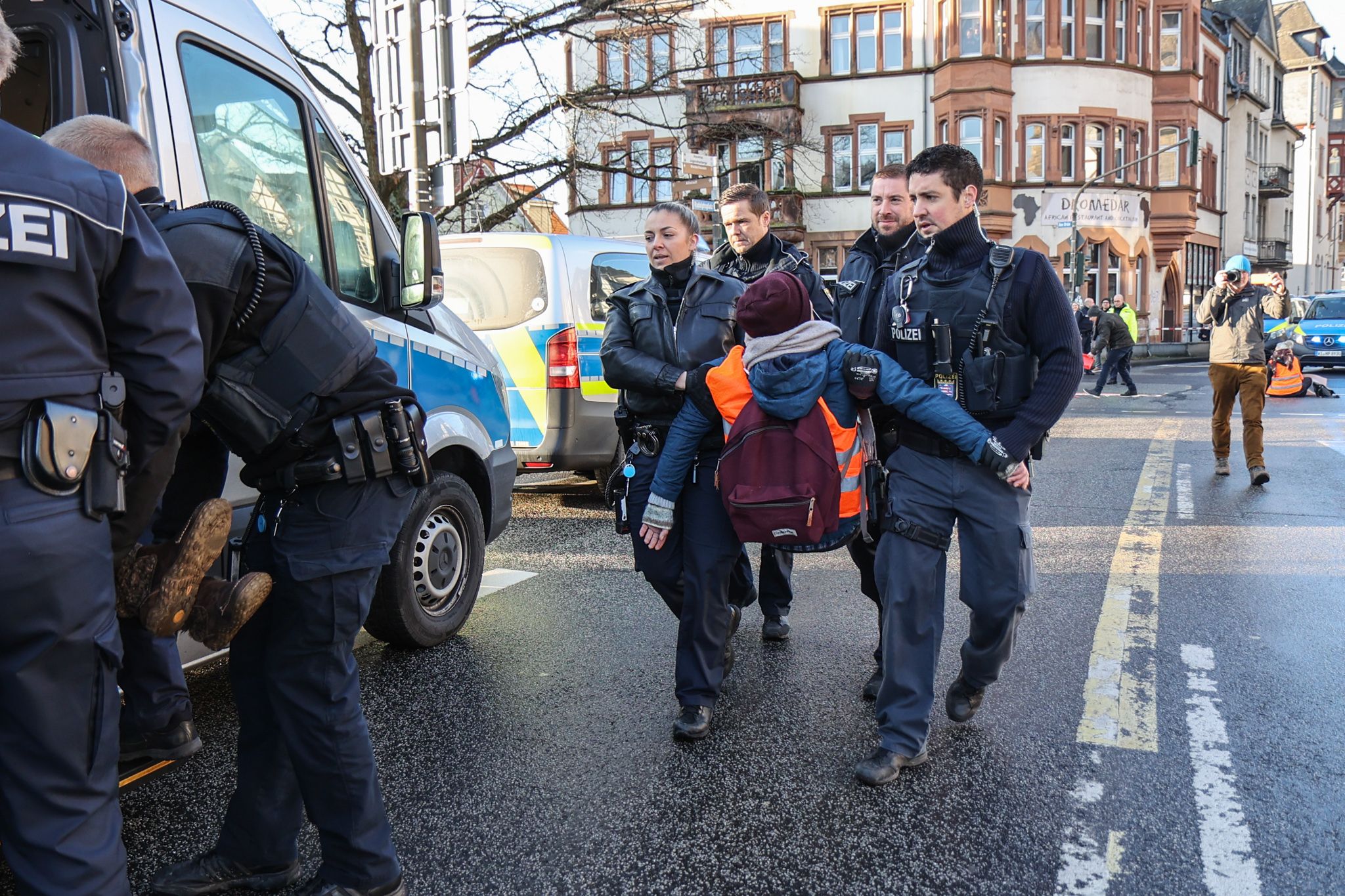 Polizisten tragen eine Klima-Aktivistin weg.