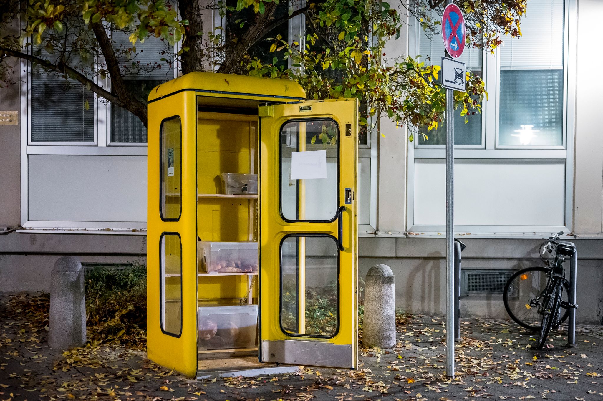 Eine «Foodsharing»-Station in einer gelben Telefonzelle ist mit Brötchen und Borten befüllt.