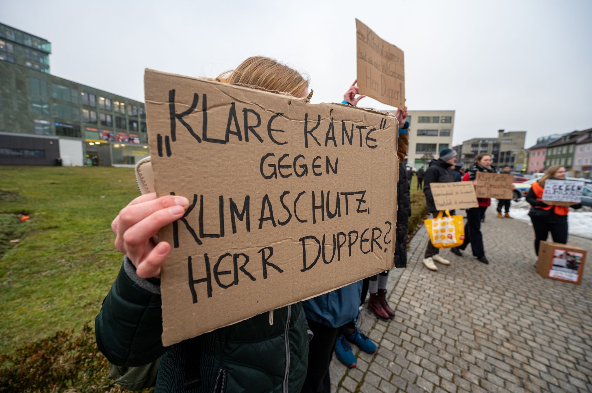 «Klare Kante gegen Klimaschutz Herr Dupper?» steht auf dem Schild eines Demonstranten am Rande einer Aktion von Aktivisten der Klimaschutzbewegung «Letzten Generation» in der Innenstadt.
