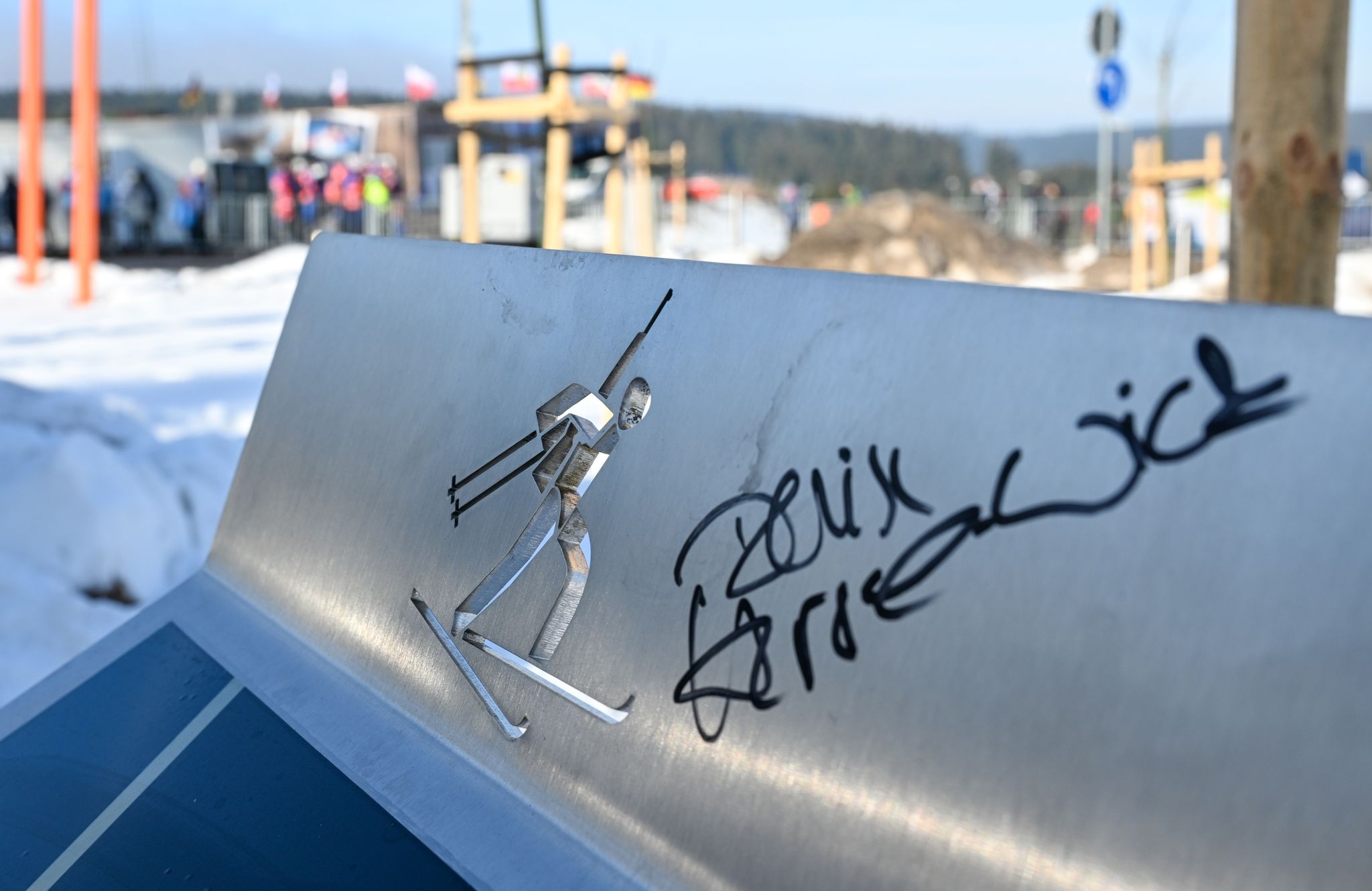 Eine Tafel für die deutsche Sprint-Weltmeisterin Denise Herrmann-Wick mit deren Autogramm steht vor einem Bergahorn am Rande der Biathlon-Arena in Oberhof.