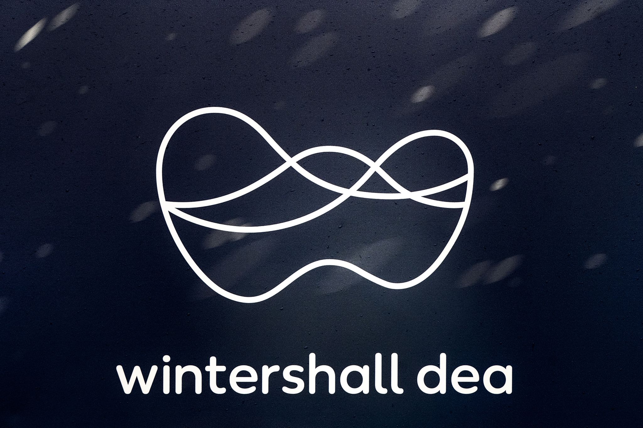 Regentropfen sind vor dem Logo von Wintershall Dea an einem Schild zu sehen.