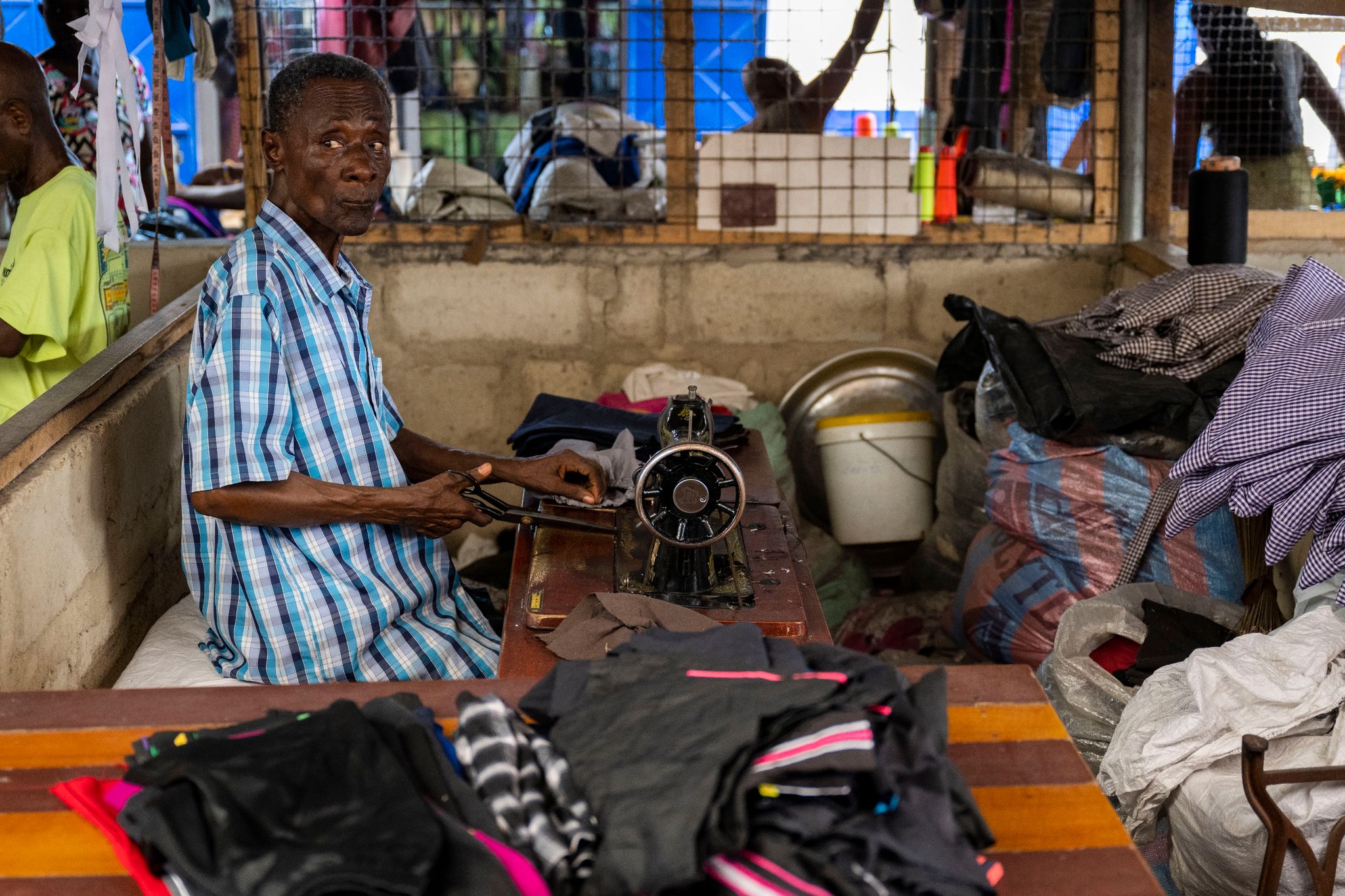 Ein Mann arbeitet auf einem Markt in Ghanas Hauptstadt Accra, wo unter anderem Kleidung aus Europa verkauft oder weiterverarbeitet wird.