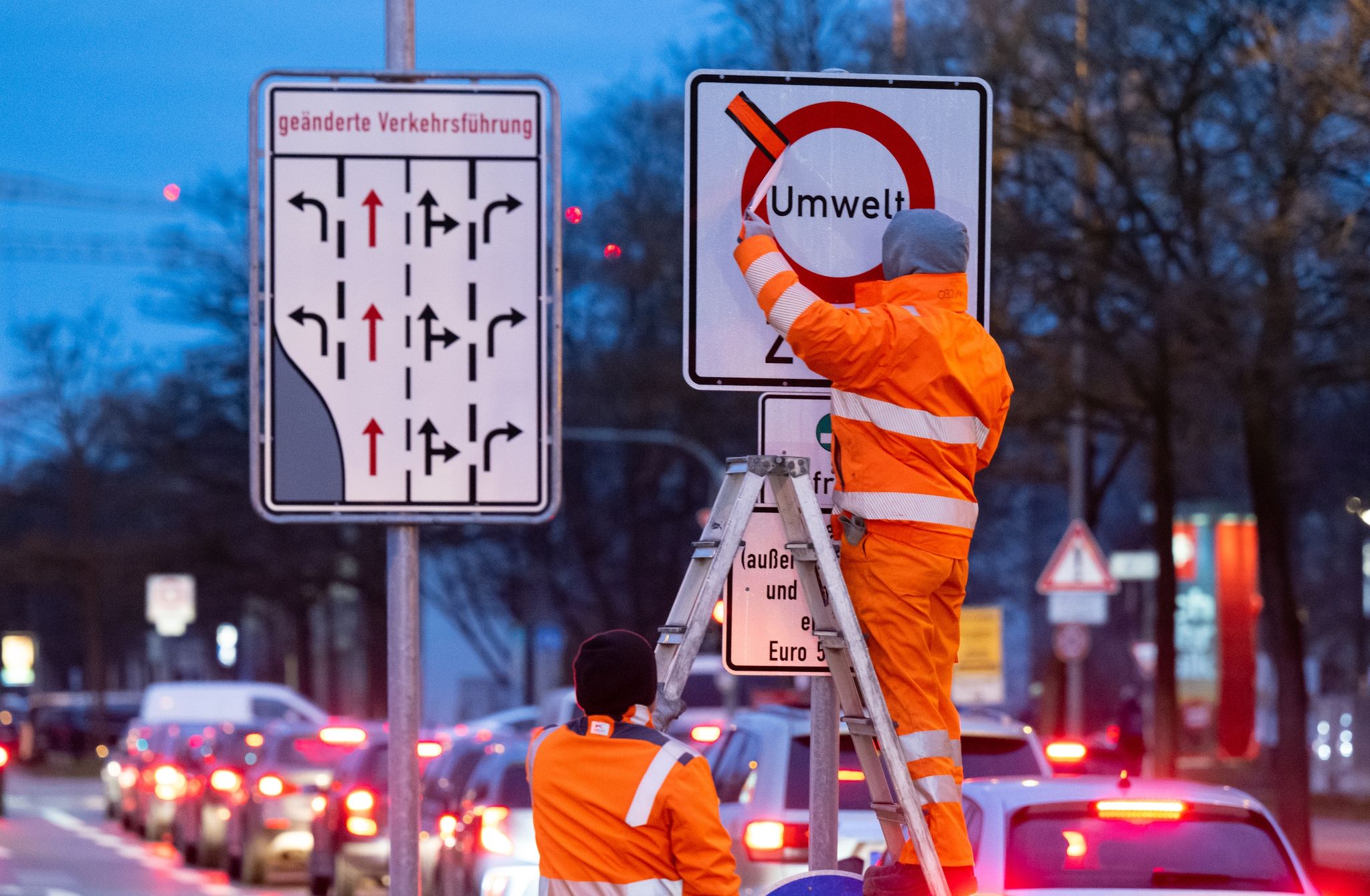Arbeiter arbeiten an einem Schild in der erweiterten Umweltzone in München.