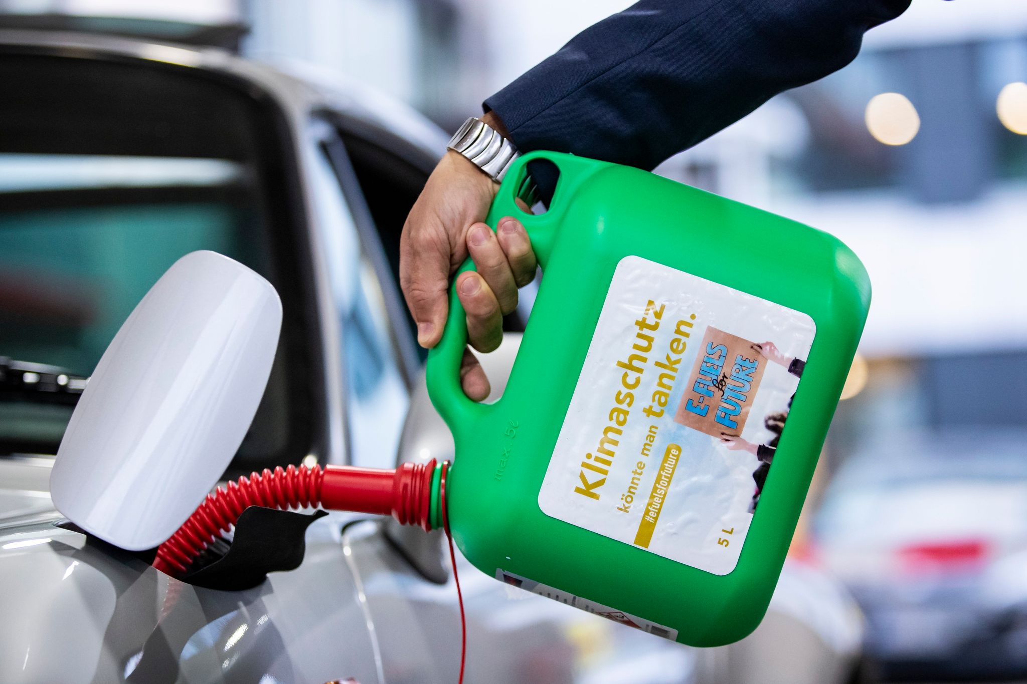 «Klimaschutz könnte man Tanken - E-Fules for Future»: 
Ein Auto wird mit einem Kanister mit E-Fuel betankt.