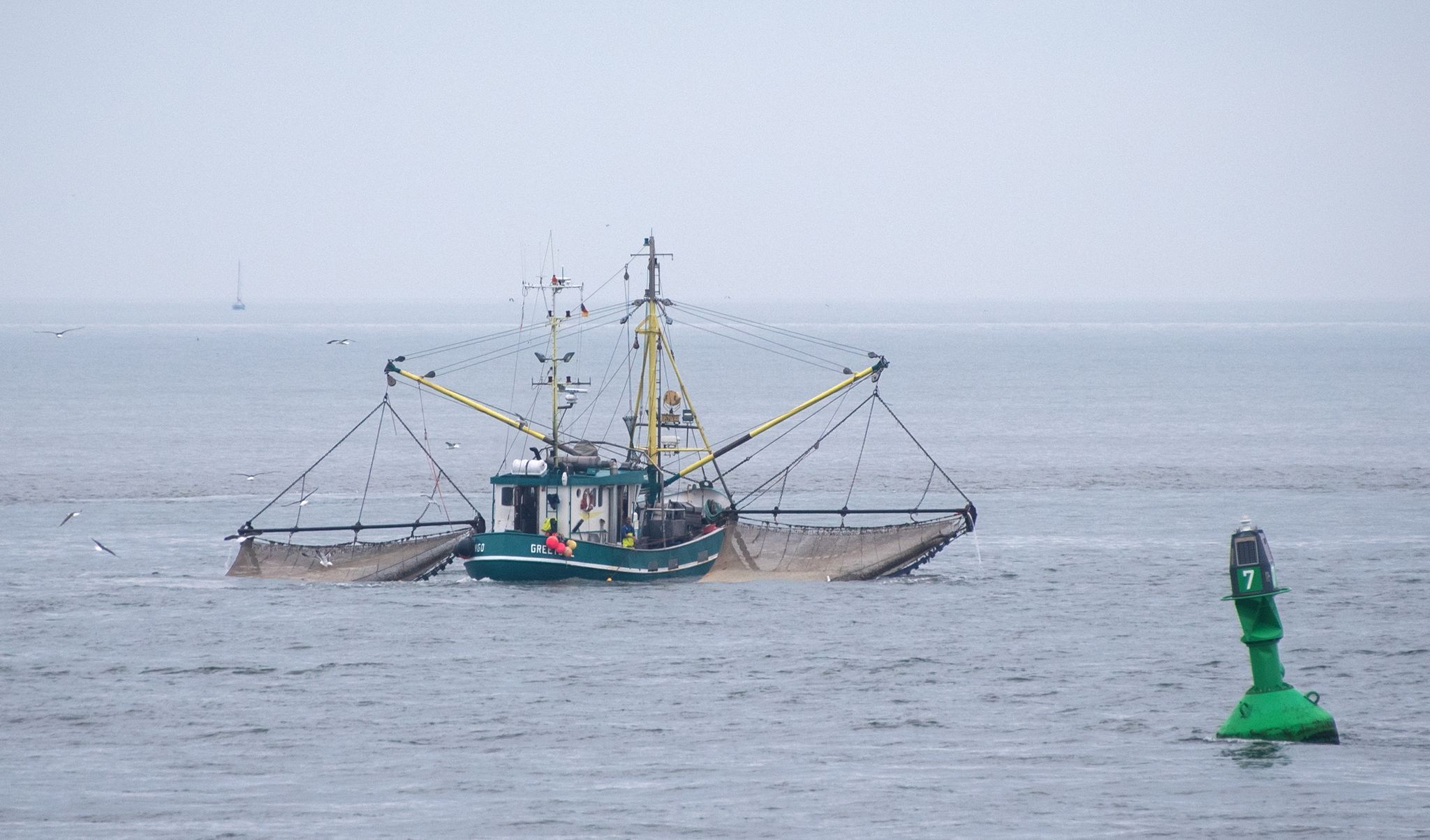Ein Fischkutter zieht seine Netze durch das Wasser der Nordsee.