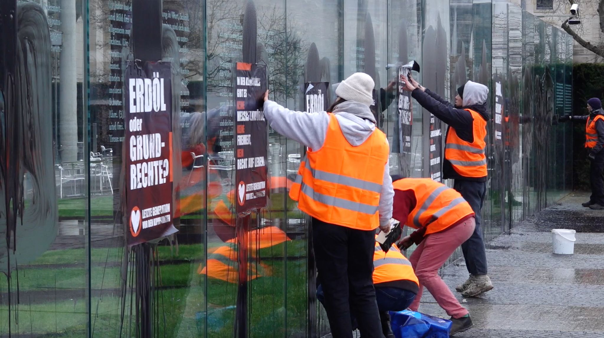 Klimaaktivisten der "Letzten Generation" beschmieren und plakatieren gläserne Grundgesetz-Skulptur am Bundestag.