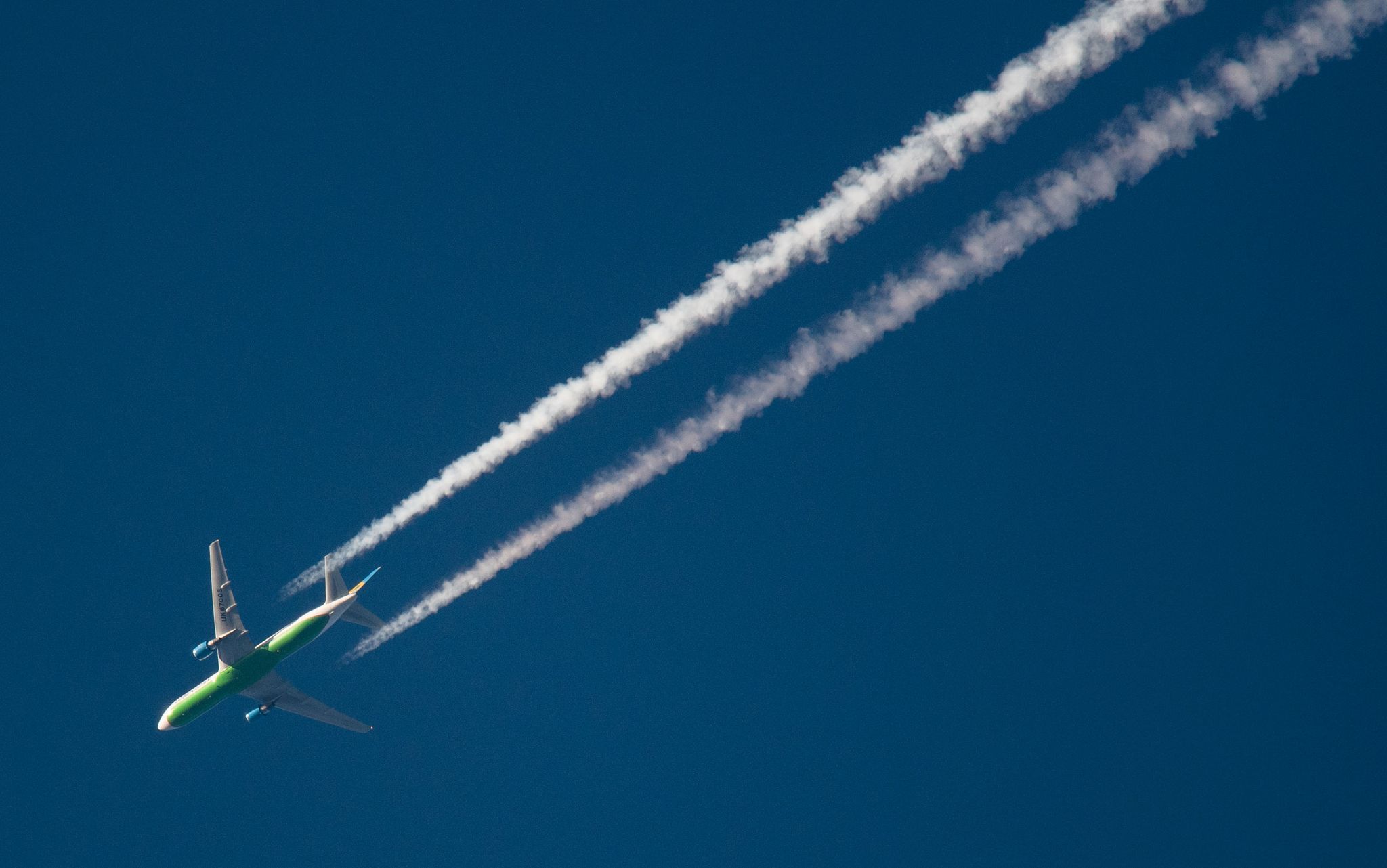 Ein Flugzeug hinterlässt Kondensstreifen am Himmel. Spätestens Mitte des Jahrhunderts soll schließlich mit grünem Wasserstoff geflogen werden.