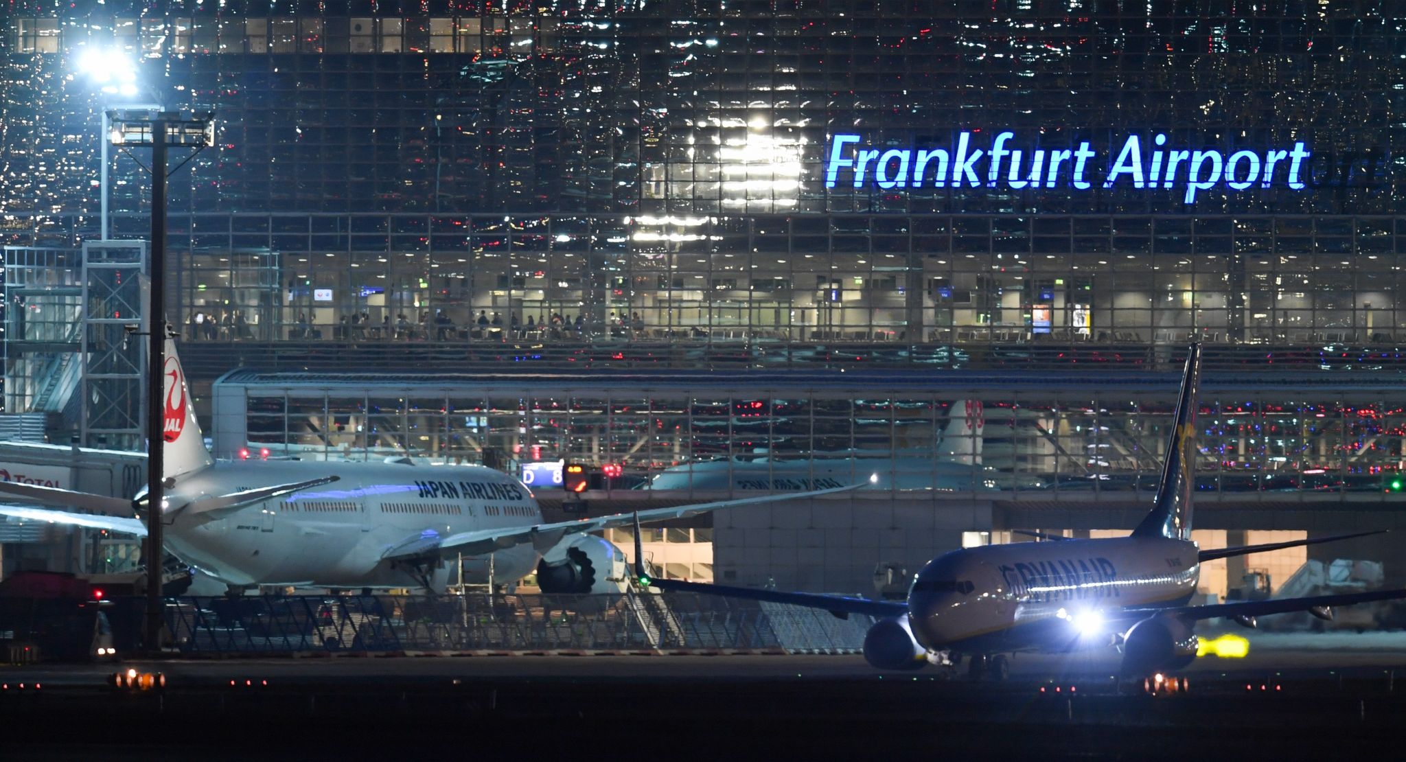 Eine Passagiermaschine rollt am Terminal 2 neben einem Flugzeug der Japan Airlines zur Startbahn.