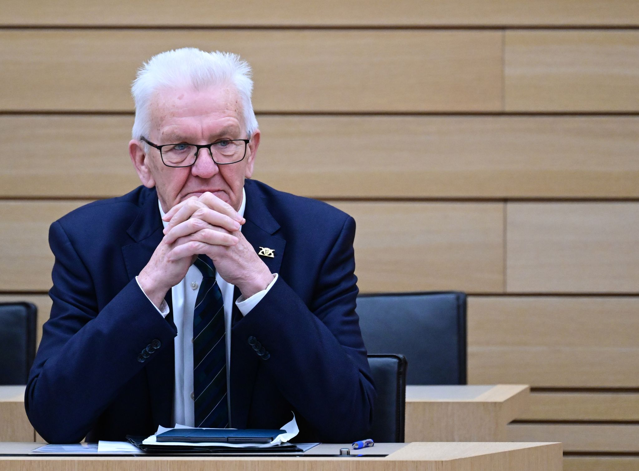 Winfried Kretschmann (Bündnis 90/Die Grünen), Ministerpräsident von Baden-Württemberg, sitzt im Plenarsaal bei einer Landtagsdebatte.
