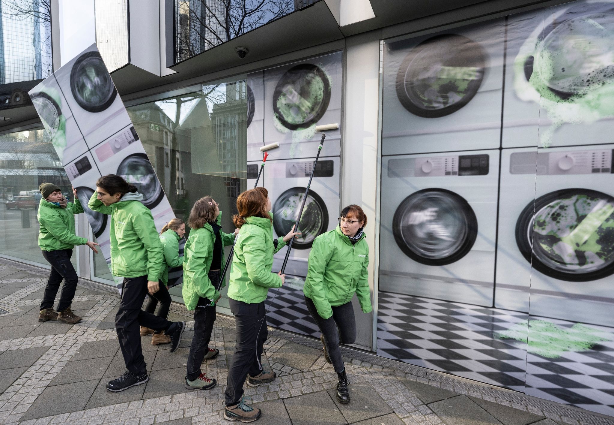 Aktivisten von Greenpeace bekleben die Deutsche-Bank-Tochter DWS mit Bildern eines „Waschsalons“.