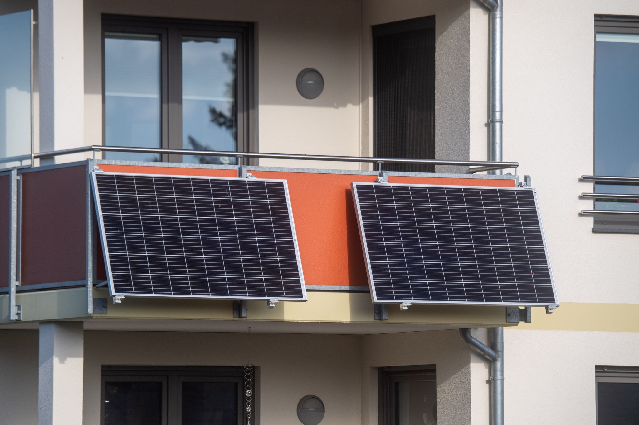 Solarmodule für ein sogenanntes Balkonkraftwerk hängen an einem Balkon.