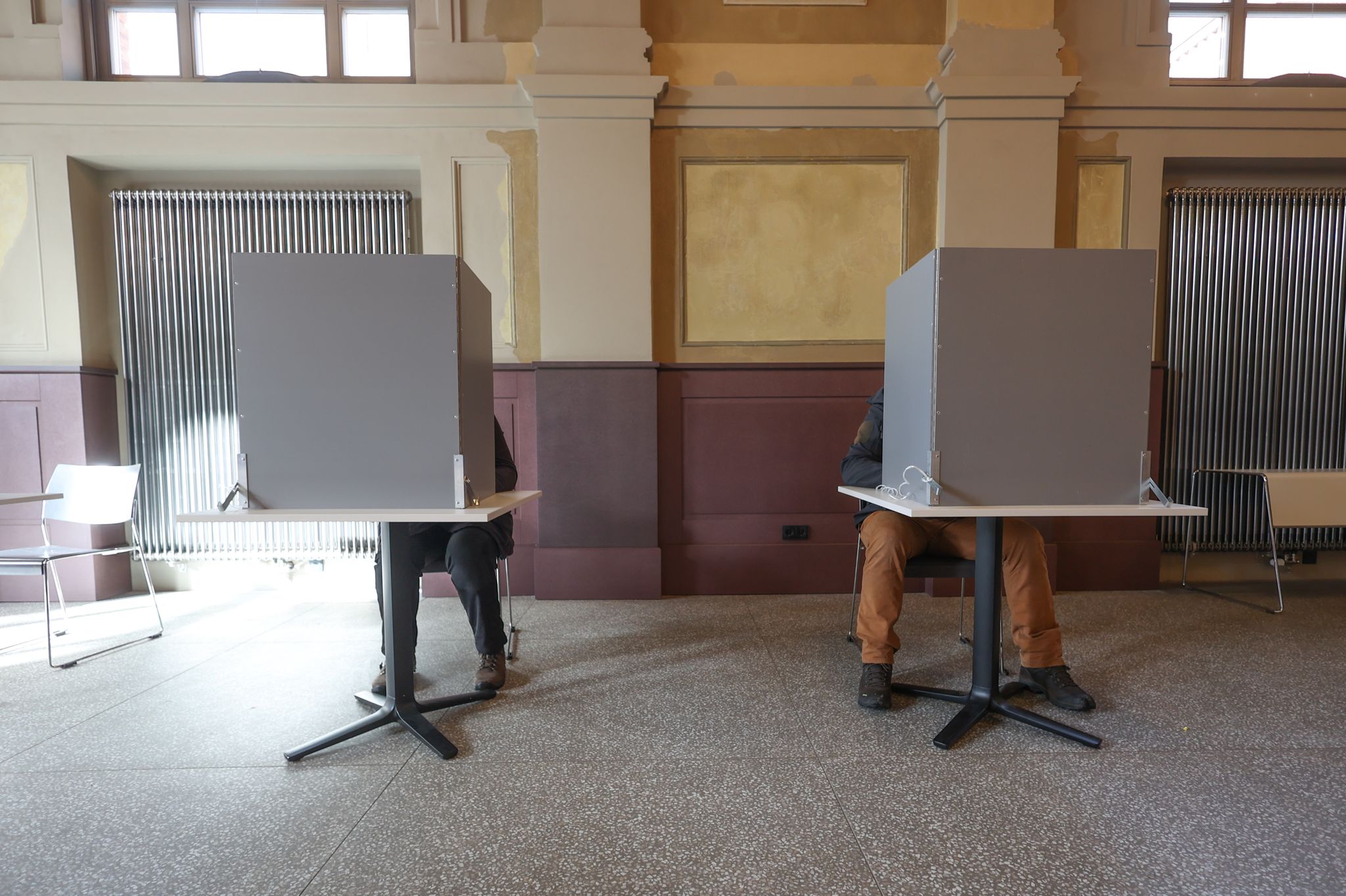 Wahlberechtigte sitzen in einem Wahllokal in Berlin.