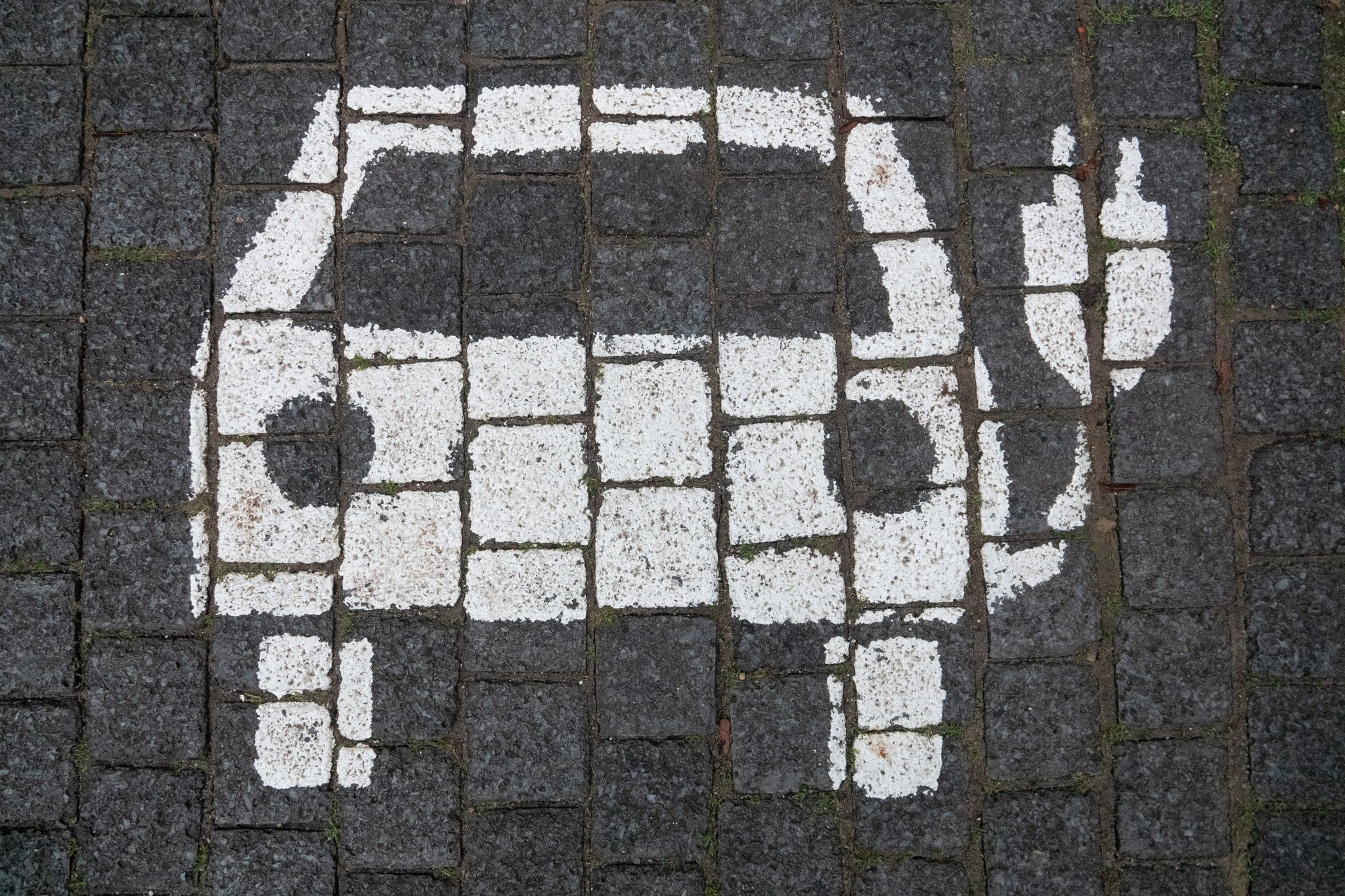 Ein Symbol markiert einen Parkplatz mit einer öffentlichen Ladesäule für Elektroautos in der Innenstadt von Hannover.