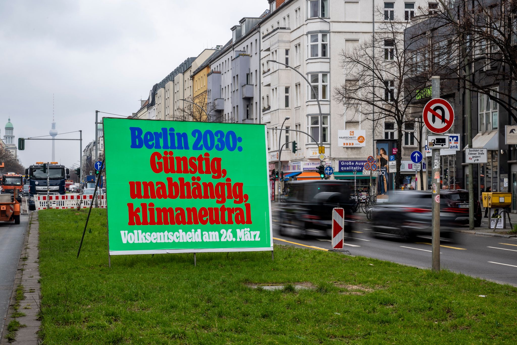 Ein Plakat mit der Aufschrift „Berlin 2030: Günstig, unabhängig, klimaneutral - Volksentscheid am 26. März“ in Berlin.