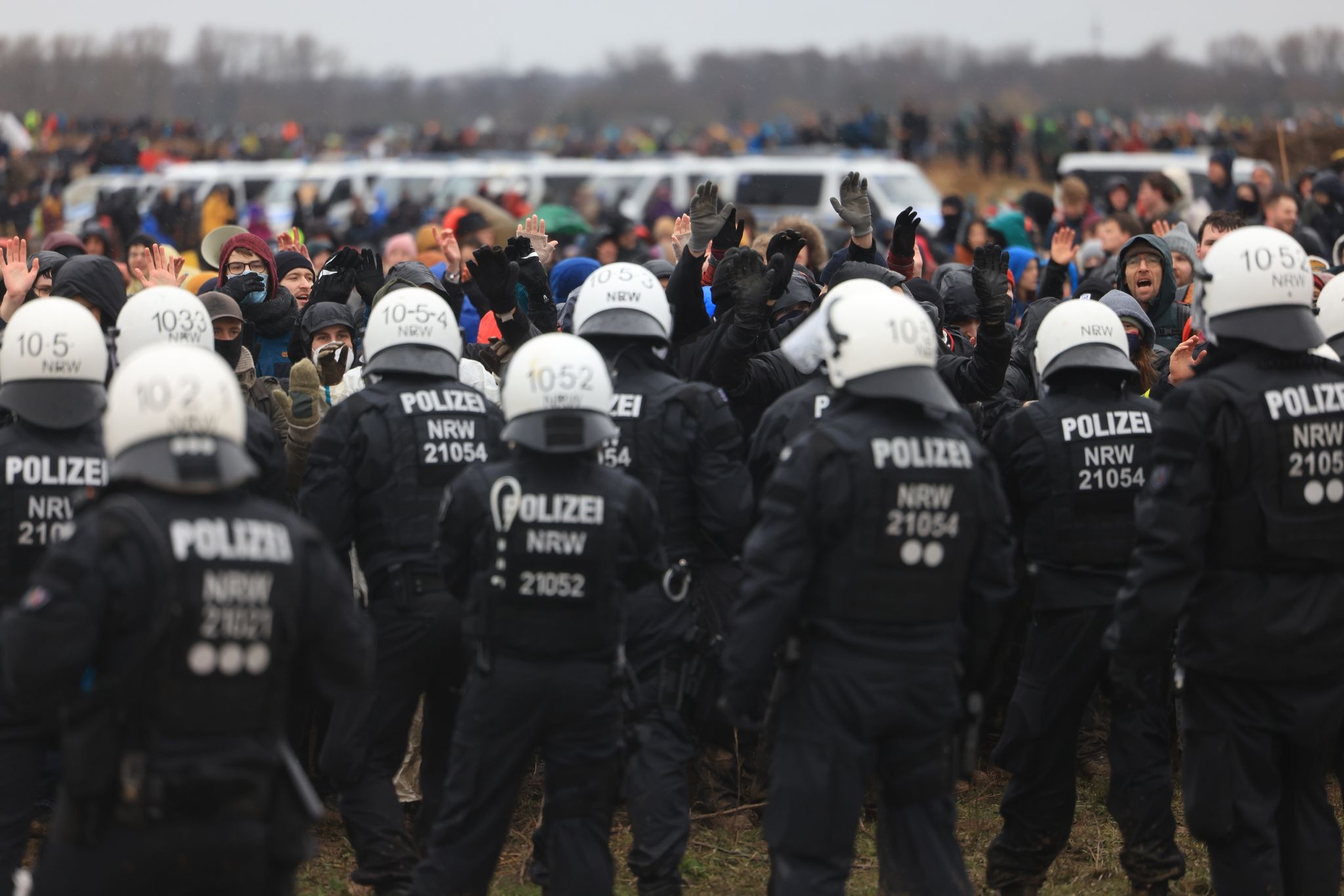 Polizisten und Demonstranten stehen sich am Rande des Braunkohletagebaus bei Lützerath gegenüber.