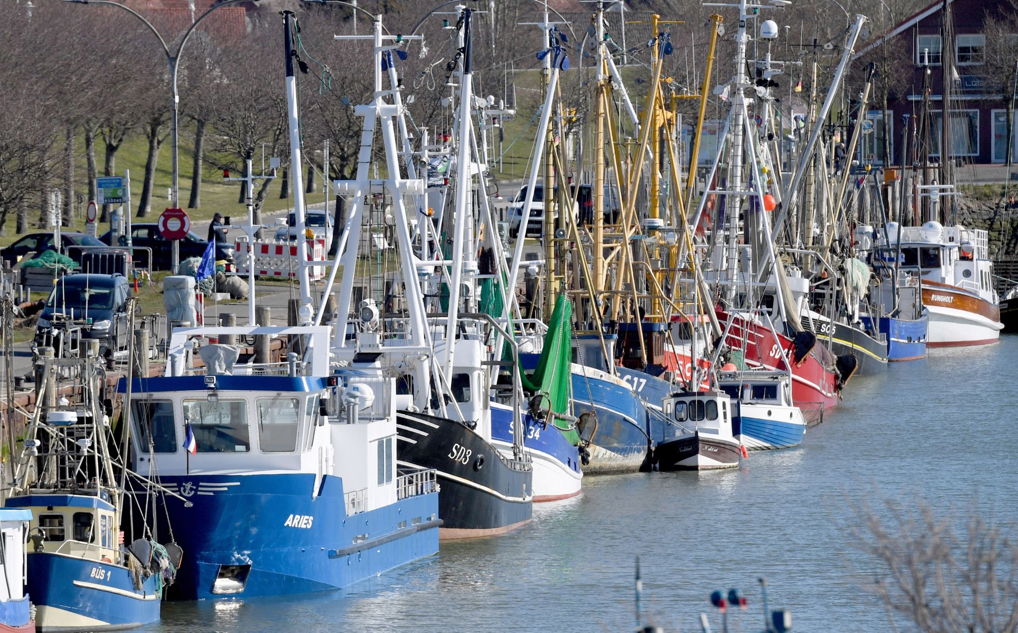 Fischkutter liegen aneinandergereiht im Hafen.