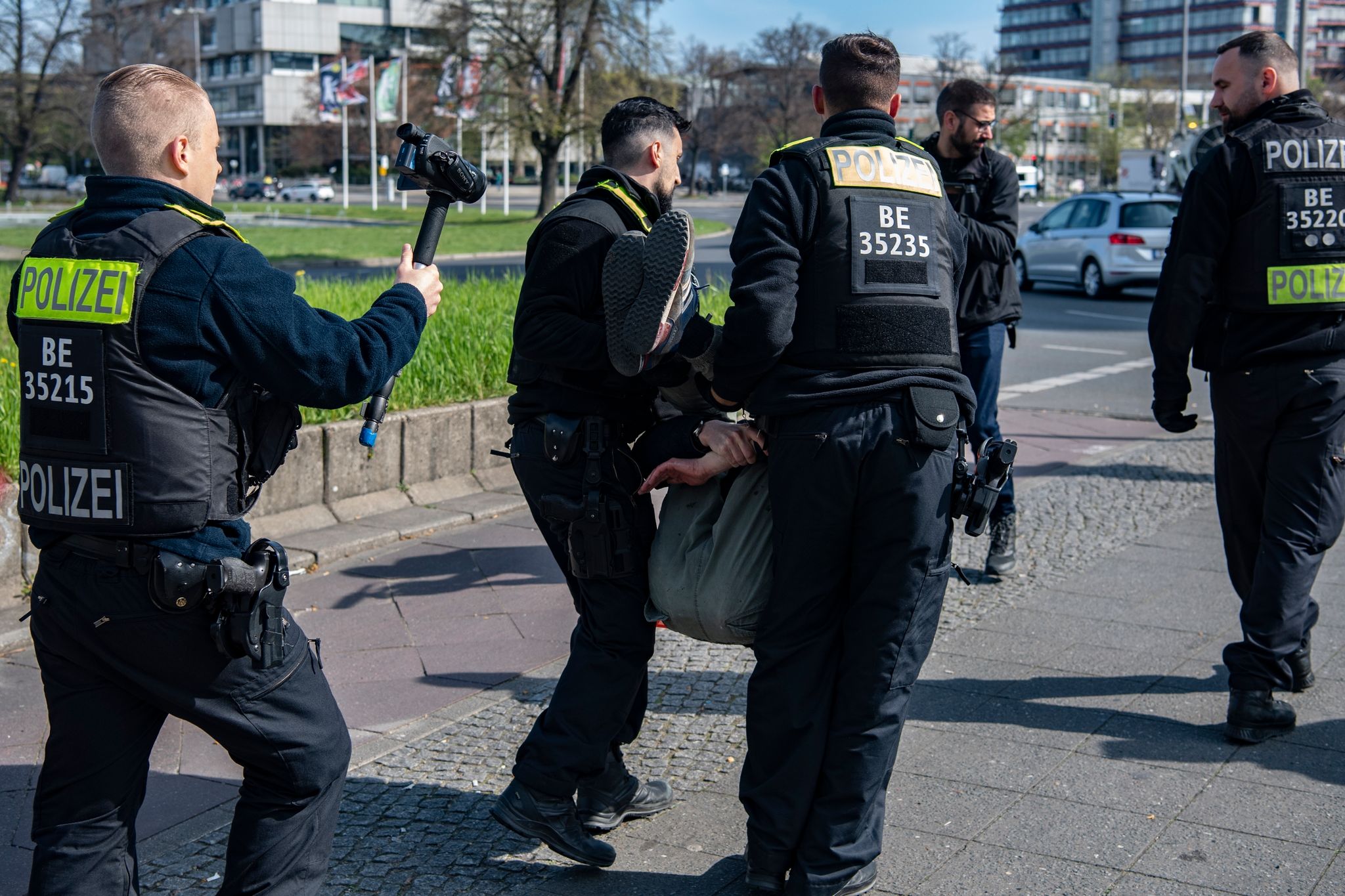 Polizeibeamte tragen am Ernst-Reuter-Platz einen Aktivisten der Letzten Generation für Klimaschutz von der Straße.