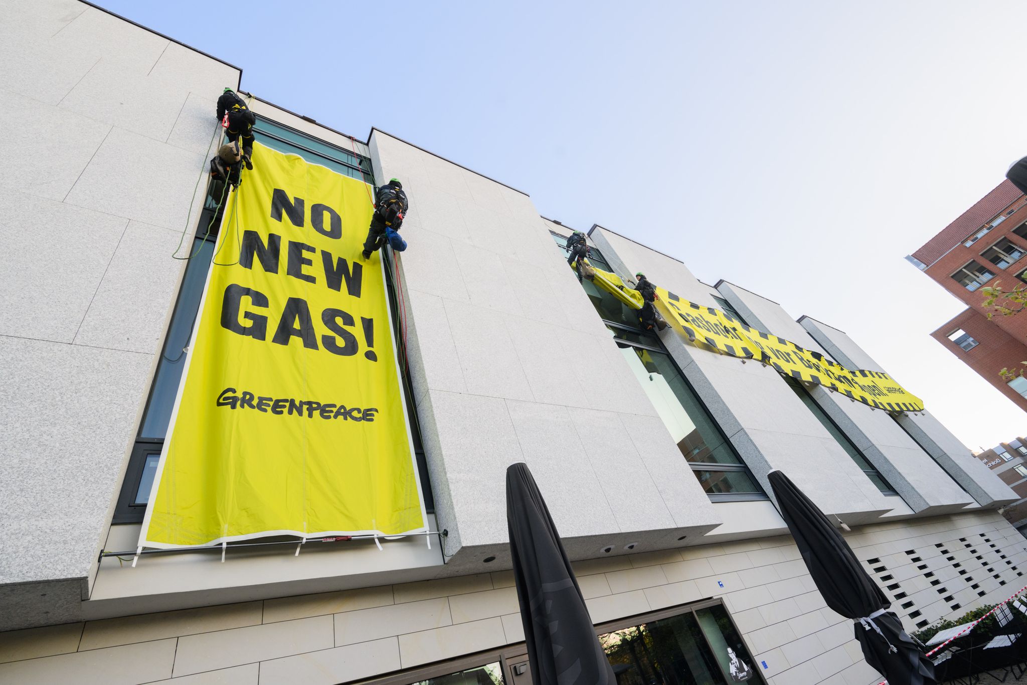 Greenpeace-Aktivisten befestigen am frühen Morgen Banner an der Fassade des niedersächsischen Landtages..